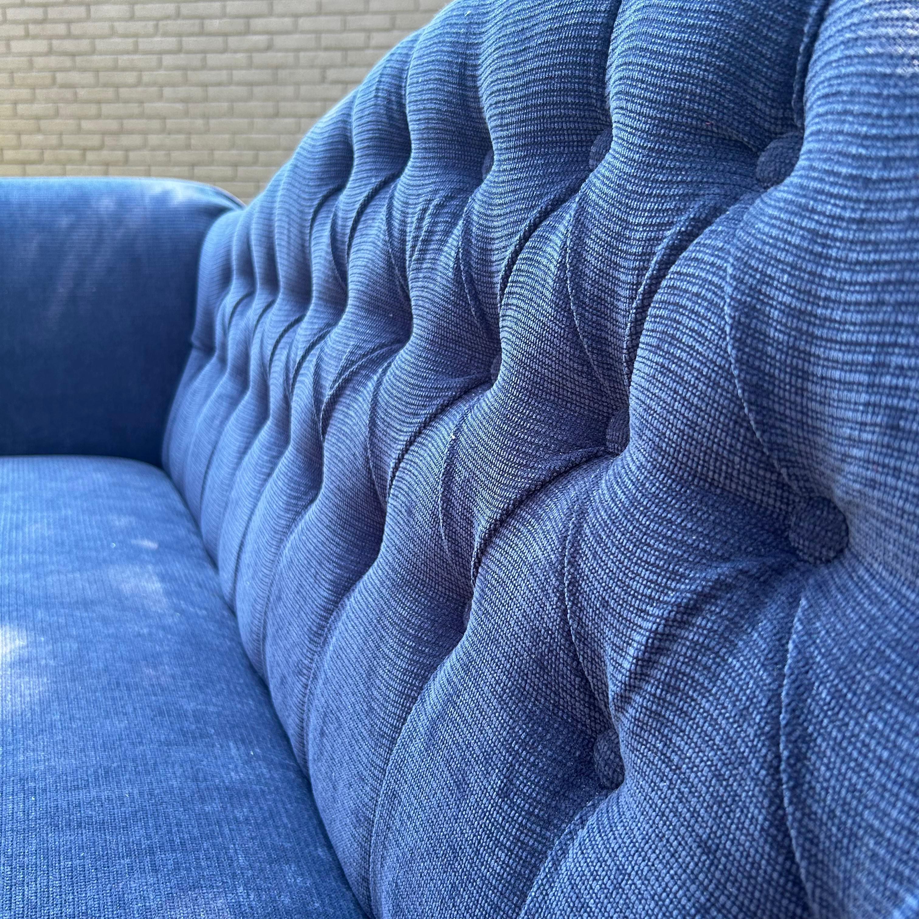 Blue on blue on blue, this vintage sofa is looking for a new place to call home. Textured corduroy in a classic navy covers the deep seat, extravagant arms, and diamond tufted back. We love the watercolor effect of the complementary fabric by Marcus