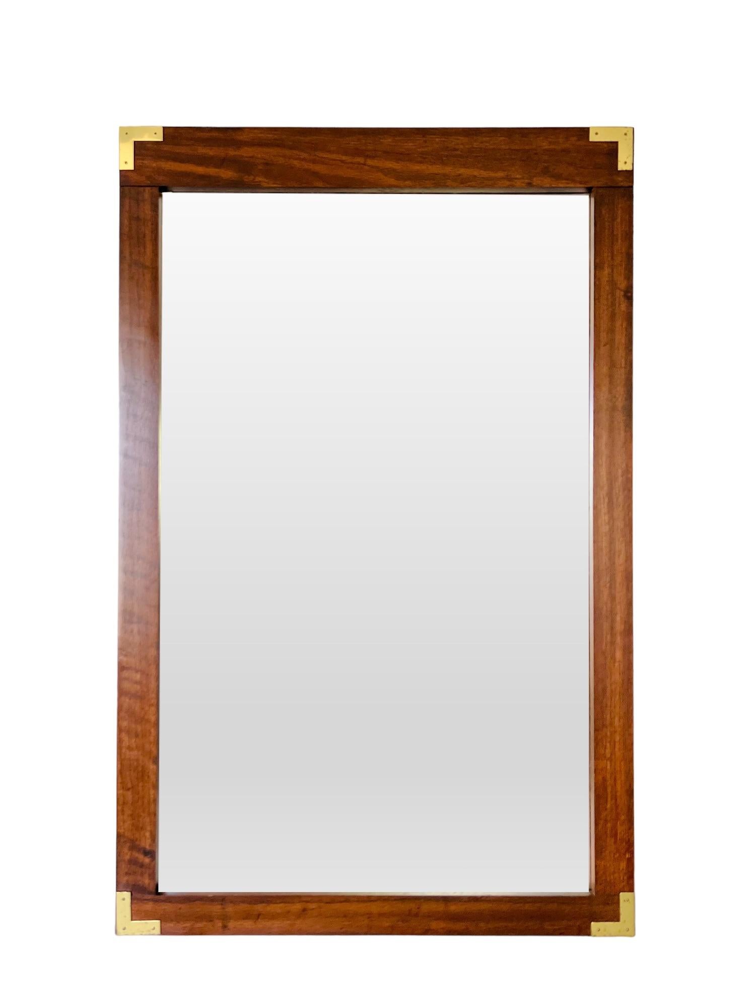 A vintage Mid-Century Modern Campaign style wall mirror. Wood frame with walnut veneer and brass plated metal corners.

Mounting wire/hardware not included - can be strung for vertical hanging (horizontal top piece is slightly taller than