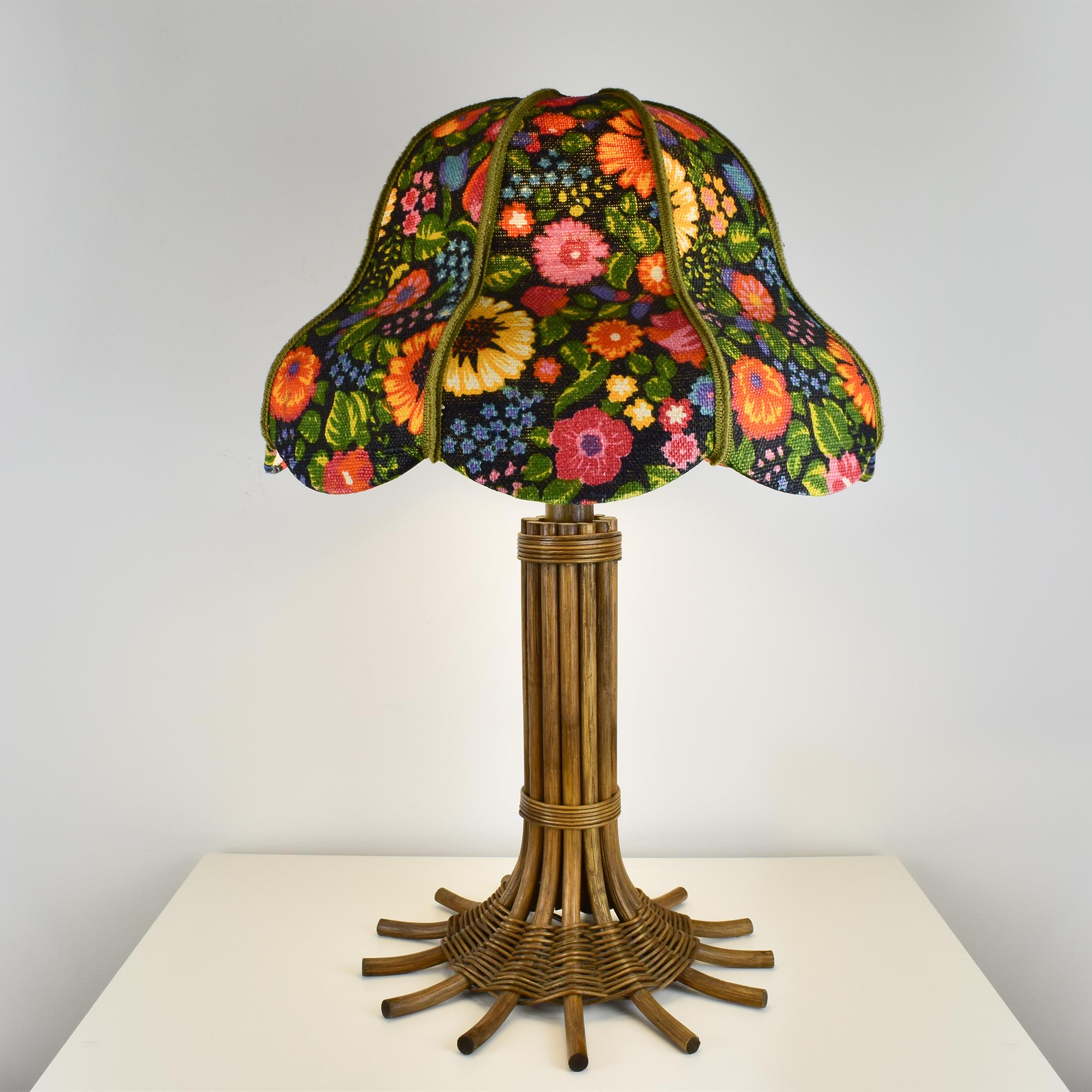 Diese Vintage-Lampe kombiniert einen wunderschönen Lampenschirm mit Blumenmuster aus Stoff mit einem Sockel aus natürlichem Schilfrohr und Rattan, der von Leola hergestellt wurde. Der lebendige Blumendruck auf dem Schirm bringt Farbe ins Spiel,