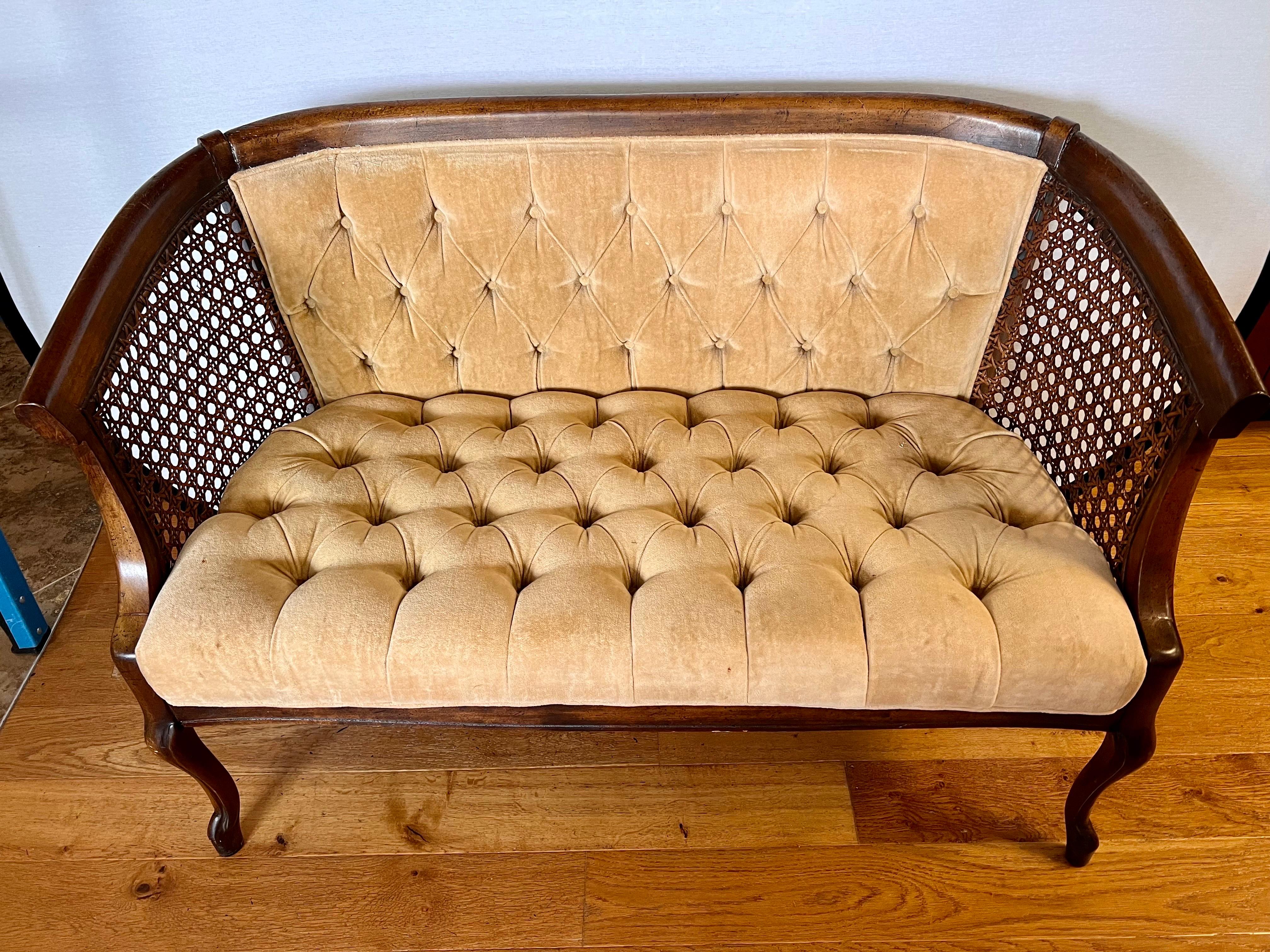 This settee combines the classic beauty of caned sides with tufted gold velvet upholstery.  The intricate caning, which is perfect, adds an air of elegance.  The fabric is original and has a few pulls but otherwise it is ok.
