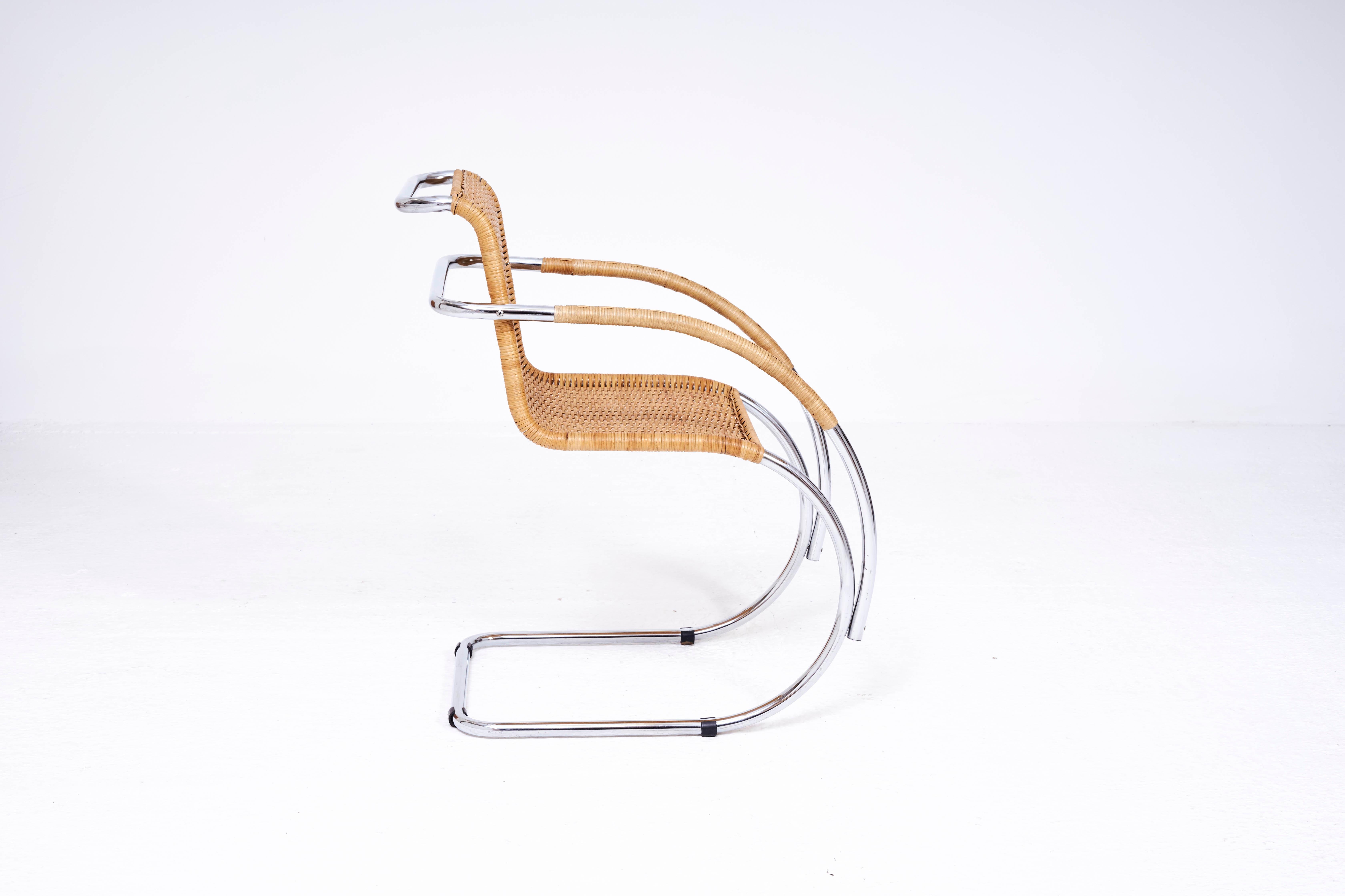 A lovely example of a woven rattan cantilever chair and the manner of Mies Van De Rohes famous MR20 design. This item is unattributed but is still a commanding piece of furniture. The rattan is in good condition with minor wear consistent with age