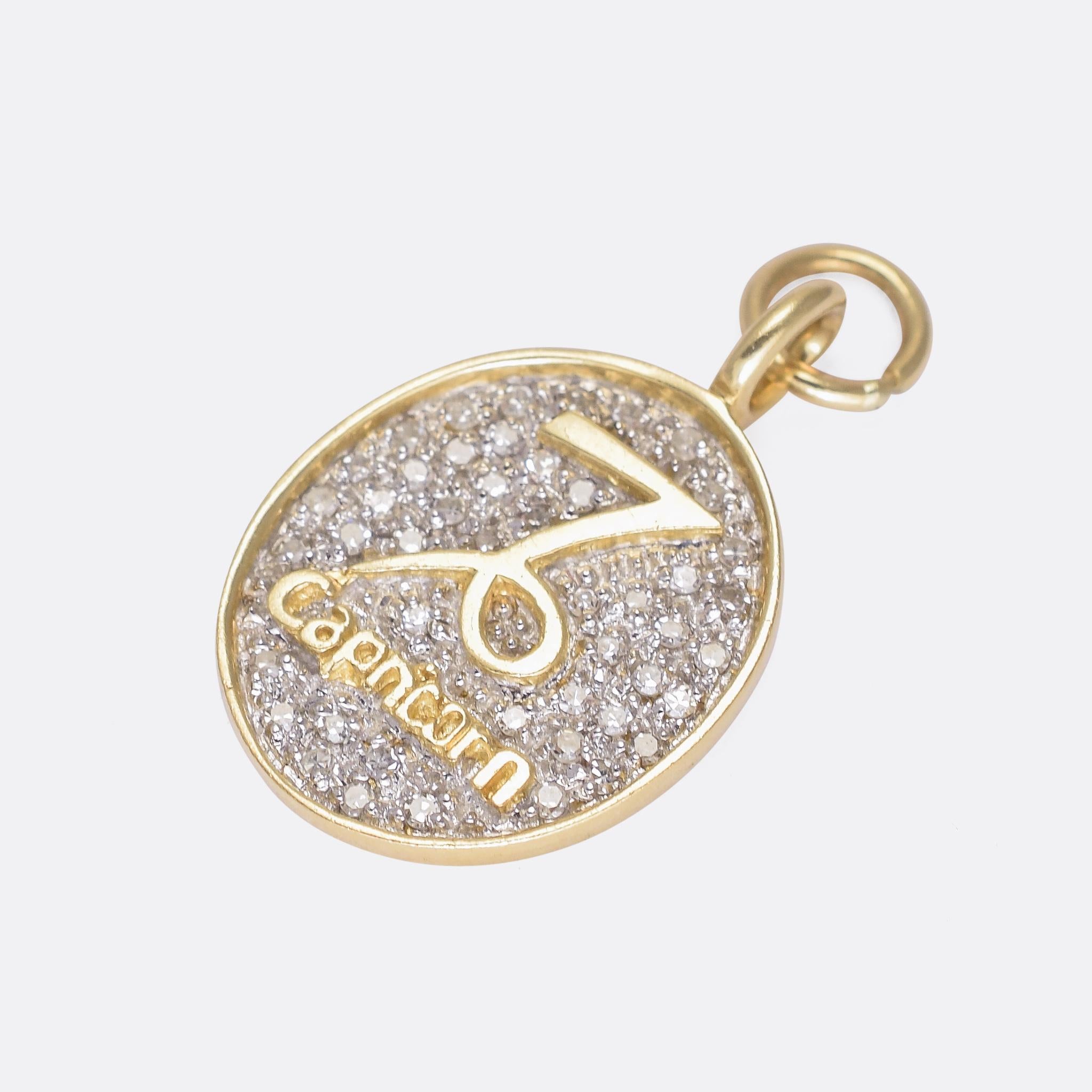 A cool vintage Capricorn pendant dating from the 1960s. It features the Zodiac symbol in gold above the word Capricorn - both in relief against a diamond paved backdrop. It's modelled in 14 karat gold throughout - a good size and very nice