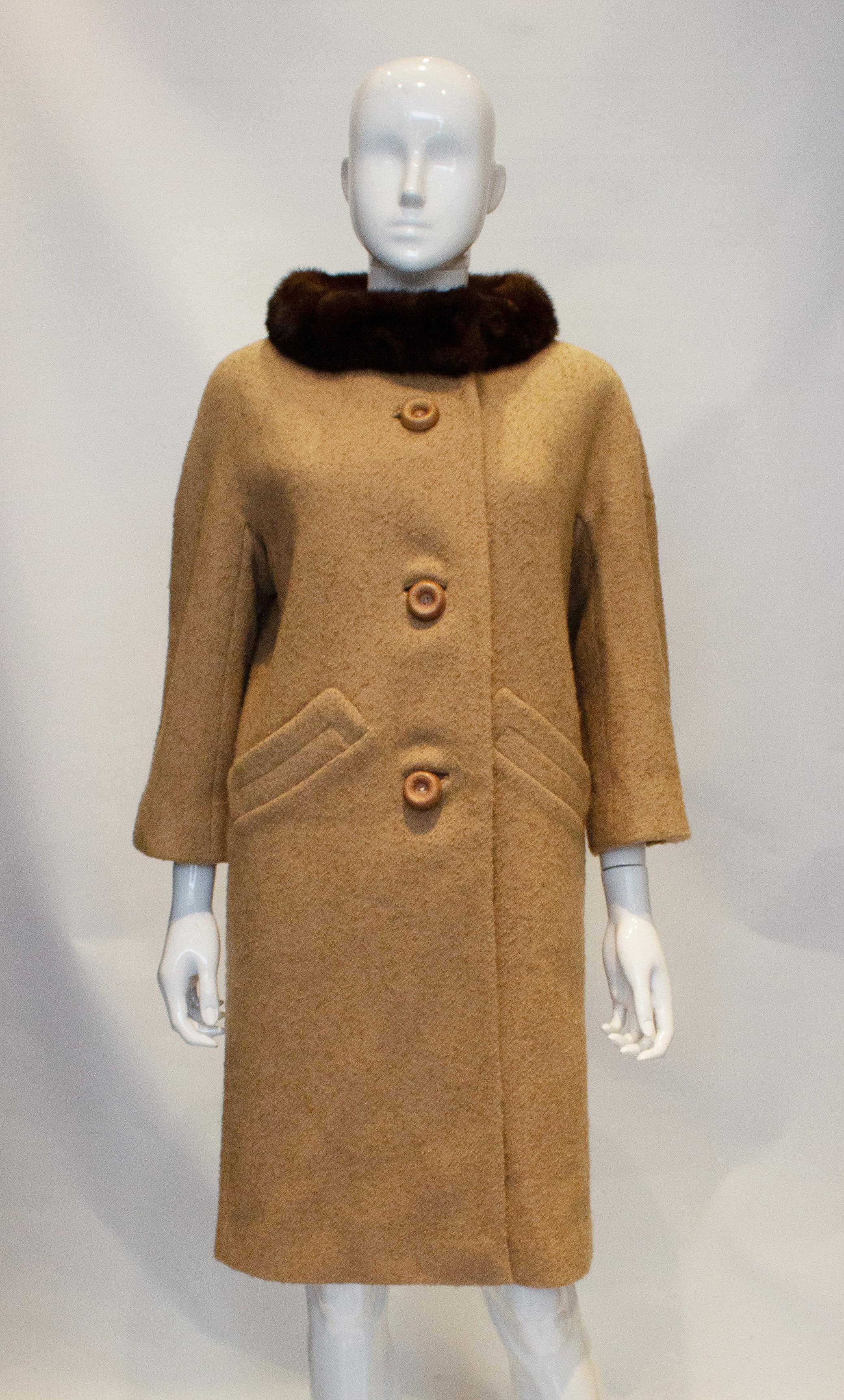 A chic vintage wool coat by Jeshiva . In a pretty caramel colour the coat has  wonderful tailoring, a three button opening and two pockets. It is fully lined. Measurements bust up to 42'', length 39''