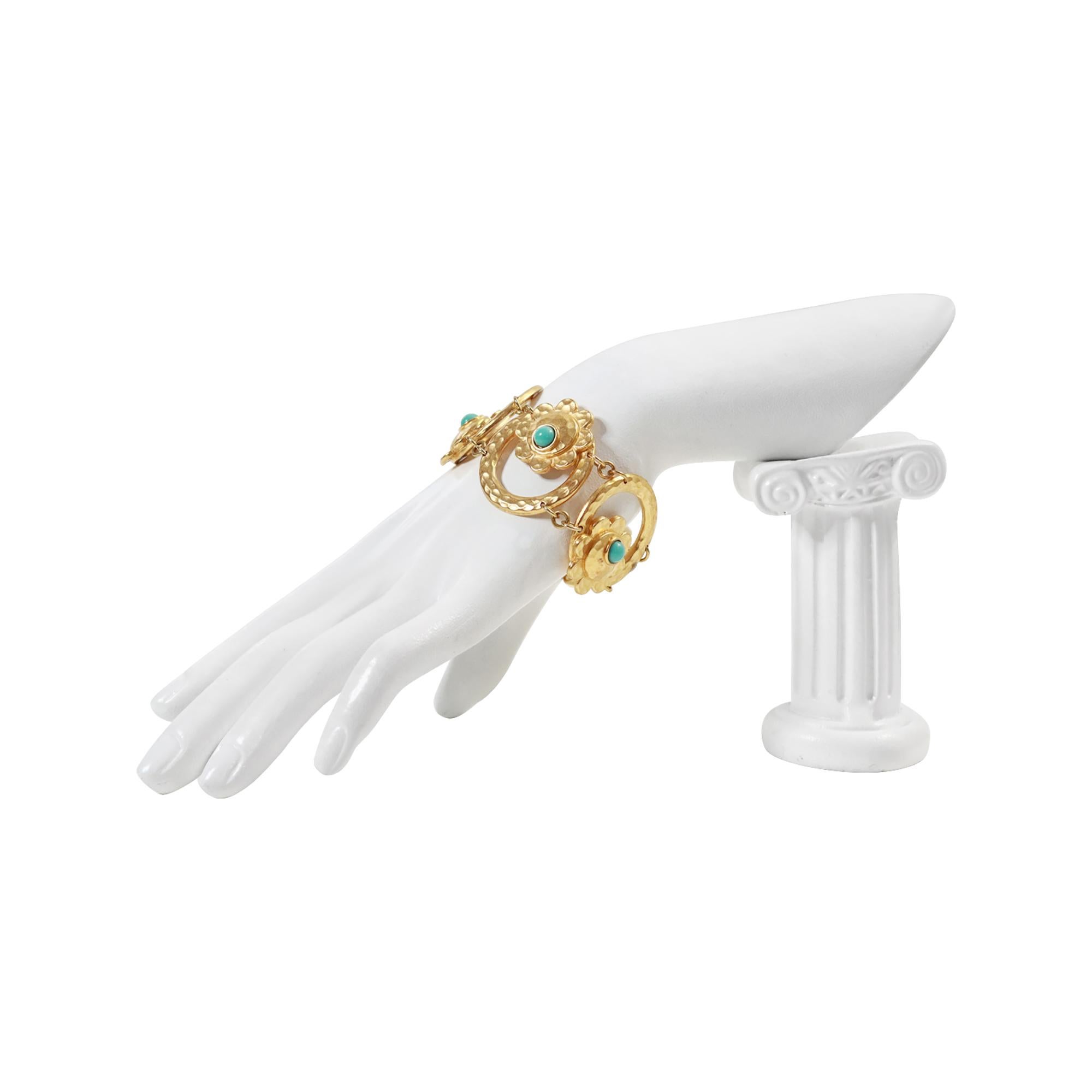 Pulsera vintage Carita Paris en tono dorado, circa años 80. Es una pulsera muy bonita y bien hecha. Los eslabones redondos están martillados, y dentro hay flores con un disco de turquesa de imitación asomando para hacer la flor. Que se asienta en