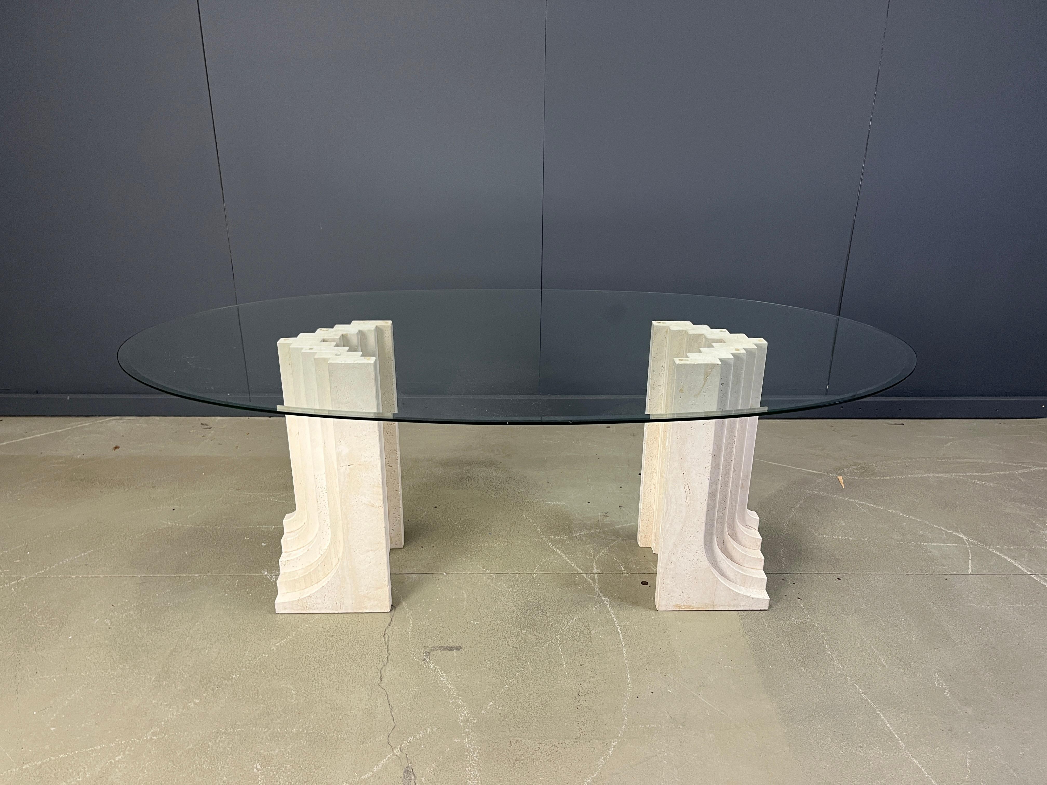 Squisito tavolo da pranzo in travertino nello stile del tavolo da pranzo Samo di Carlo Scarpa.

Bellissimo pezzo architettonico realizzato in travertino massiccio con uno spesso piano in vetro ovale smussato

Un design senza tempo.

Le due basi in