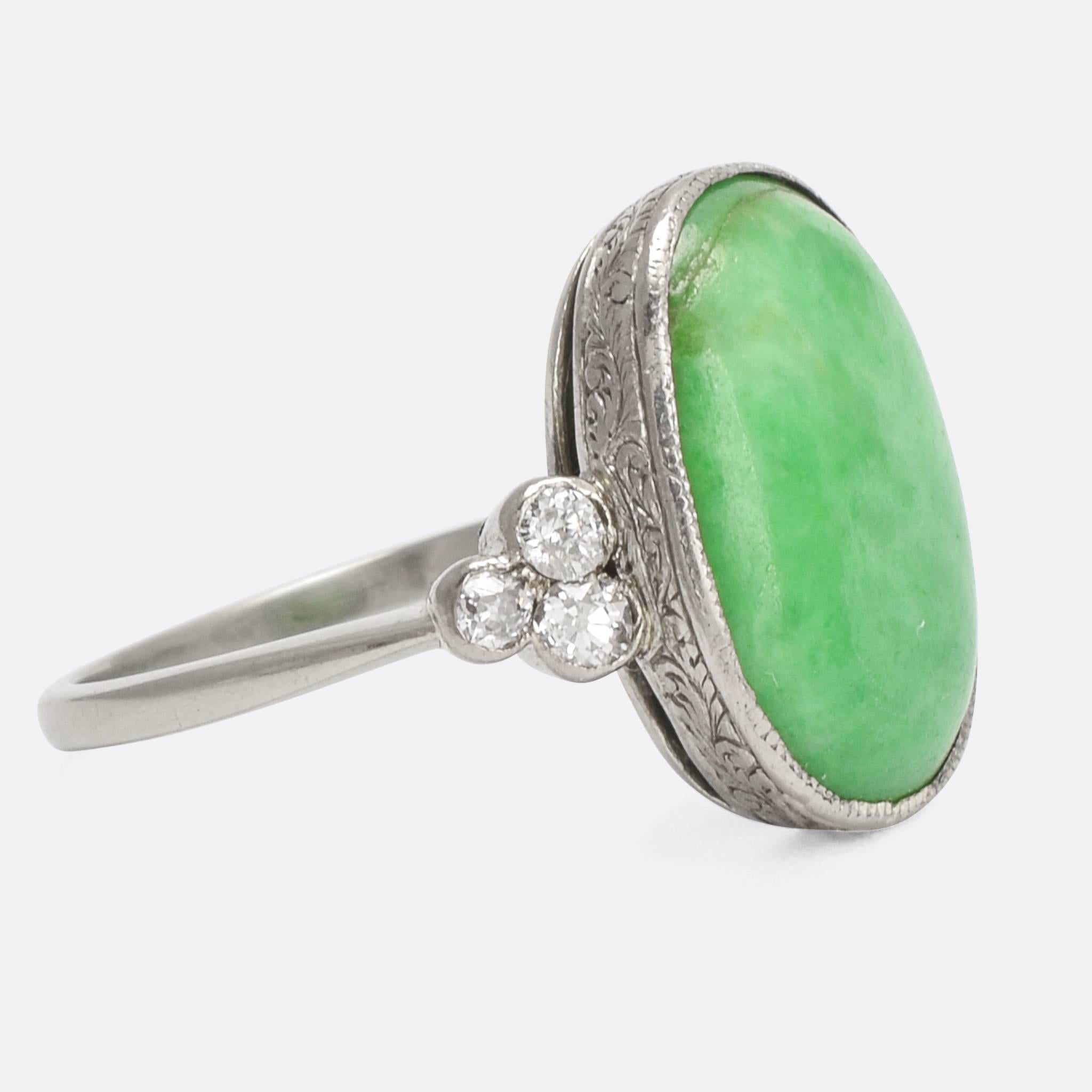 A superb antique Jade cocktail ring, dating from c.1910. Each shoulder is set with a three-stone cluster of old Euro diamonds in millegrain collet settings. Modelled in platinum throughout, with fine hand-chased detailing around the principal