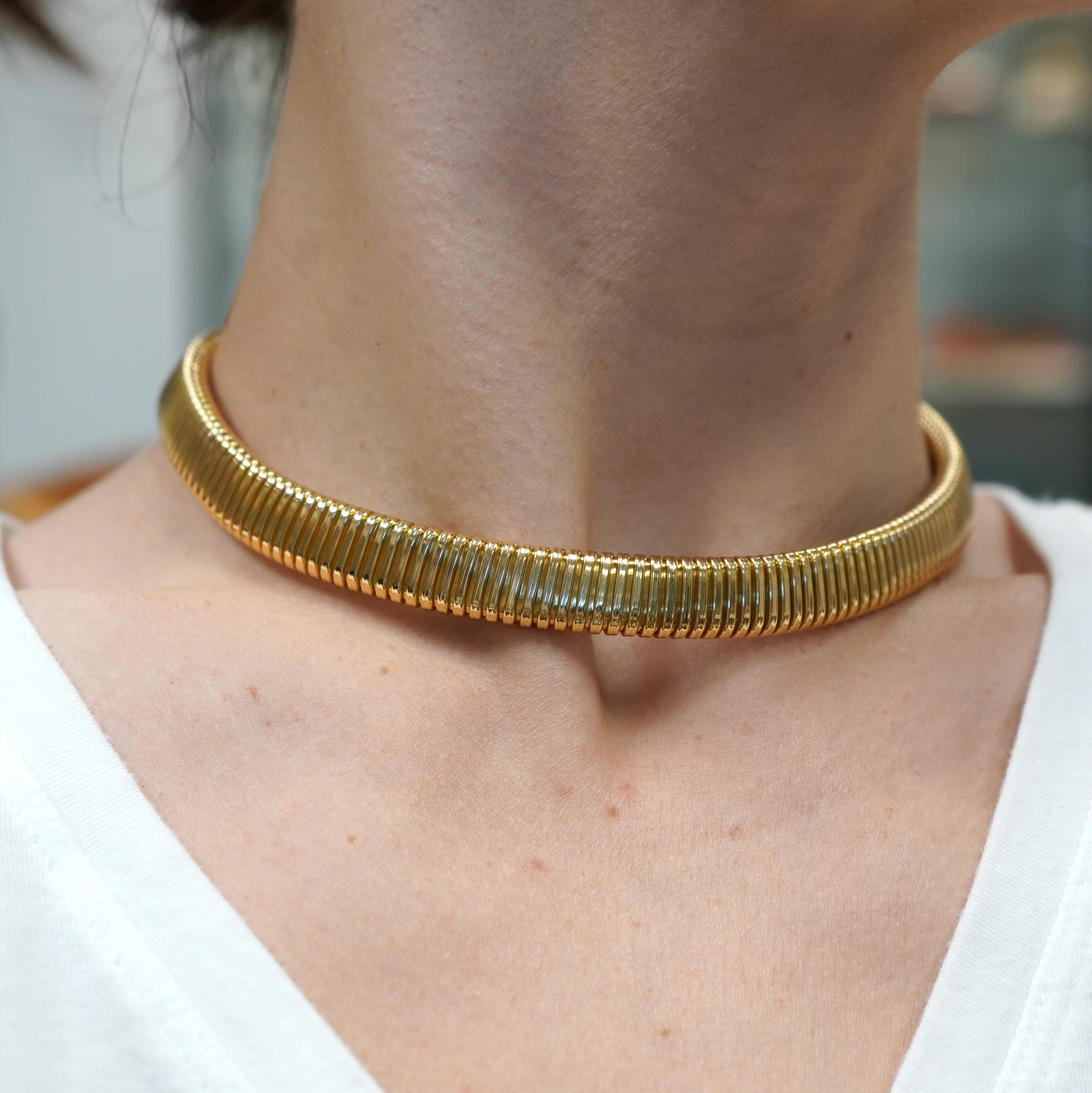Questa collana tubogas di Carlo Weingrill è realizzata in oro 18 carati e presenta un design flessibile e arrotolato tipico dello stile tubogas. La collana misura 14,25 pollici di lunghezza, il che la rende ideale per essere posizionata proprio
