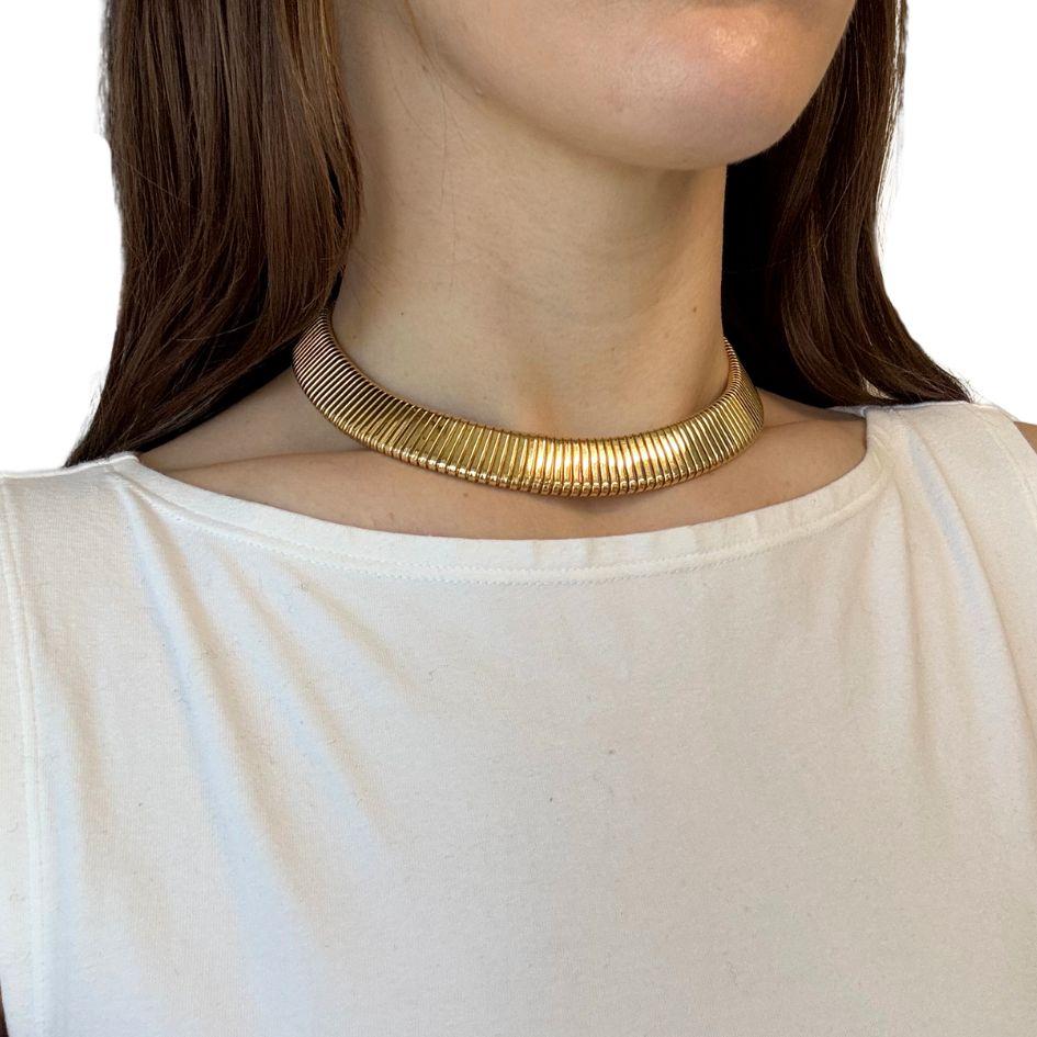 This circa 1990s Carlo Weingrill 18k gold Tubogas choker necklace is a bold and timeless example of Italian goldsmithing. The necklace is crafted in solid 18k yellow gold and measures 15 inches in length with a width of 5/8 inch. It weighs 96.8