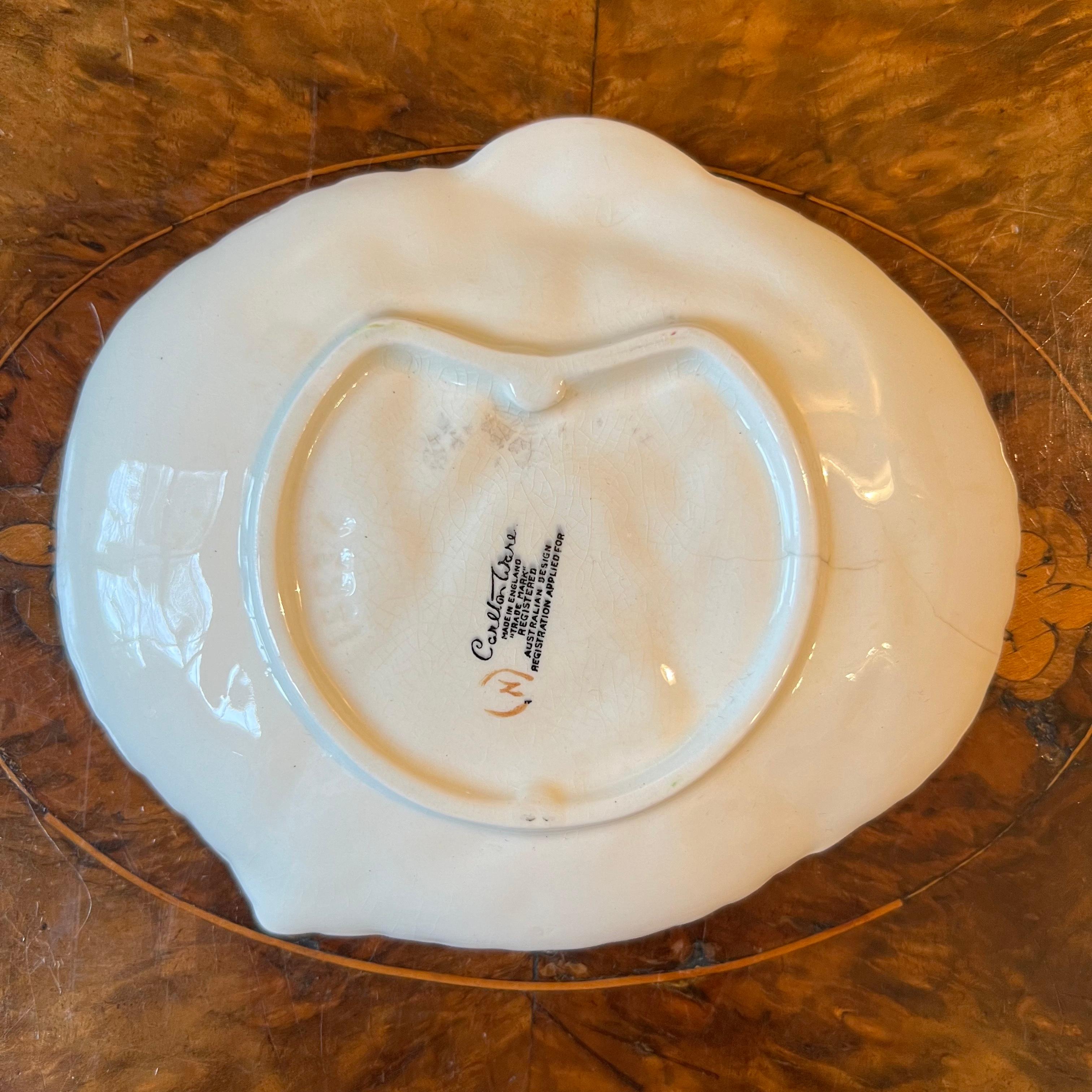 Fox glove flower design, yellow background, crazing, stamped Carlton Ware 

Circa: 1960s

Material: Porcelain 

Country Of Origin: England

Measurements: 1cm high, 12.5cm length, 14.5cm width

