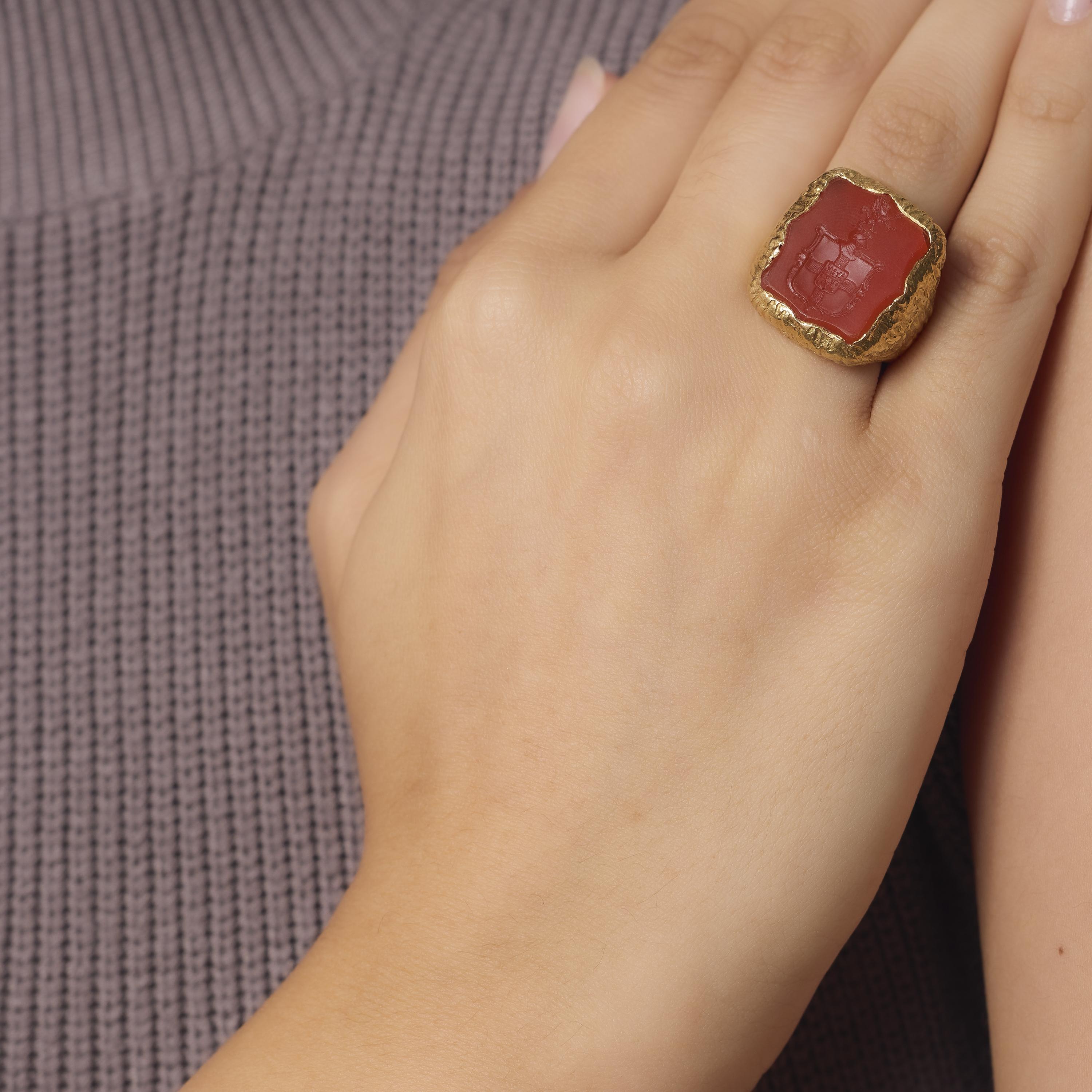 This vintage 18k yellow gold cocktail ring showcases a richly colored carnelian intaglio, carved and framed in a bold gold setting. Crafted in the 1980s, its impressive scale and timeless design evoke the elegance of ancient motifs reimagined with