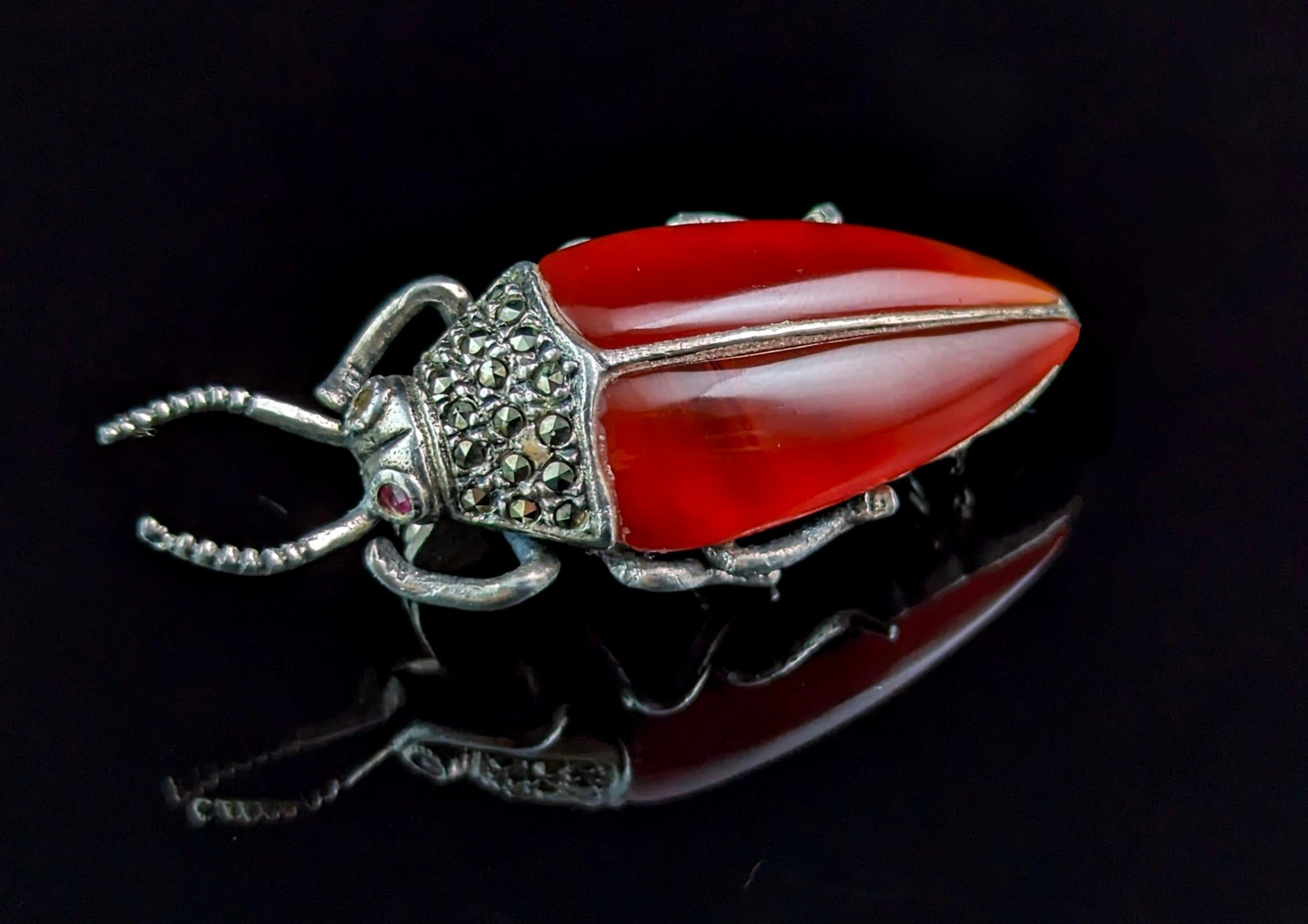 A wonderful vintage Art Deco revival beetle brooch.

The style is reminiscent of the Egyptian revival jewellery of the Art Deco era.

It is crafted in sterling silver and is a fairly heavy piece for the size, the wings are made from carved and