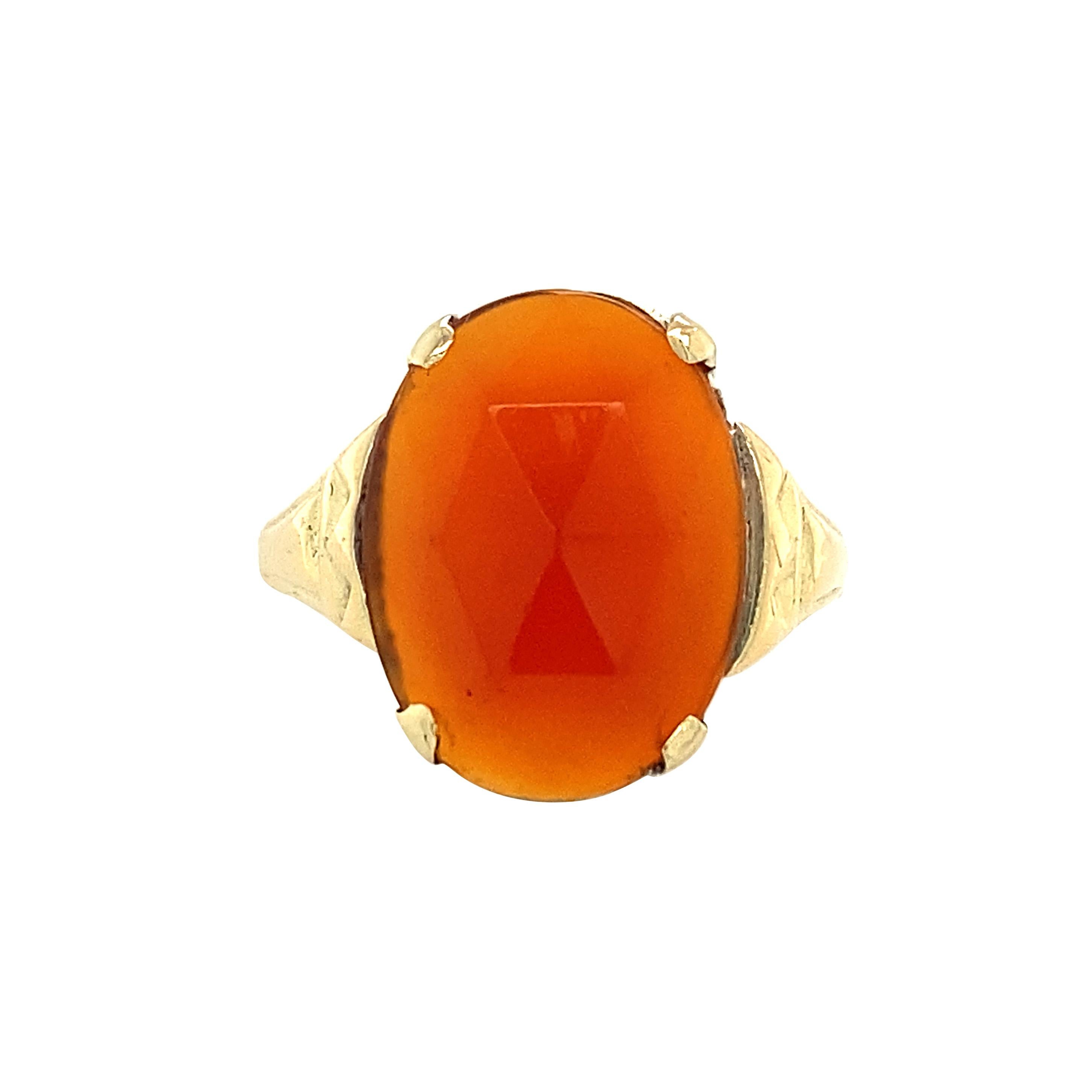 A lovely treasure, this ring is set with a juicy rose-cut carnelian gemstone, mounted in 12 karat yellow gold. Echoing the angular facets on the face of the gemstone, the shoulders of this ring are patterned and decorated with triangular motifs. Set