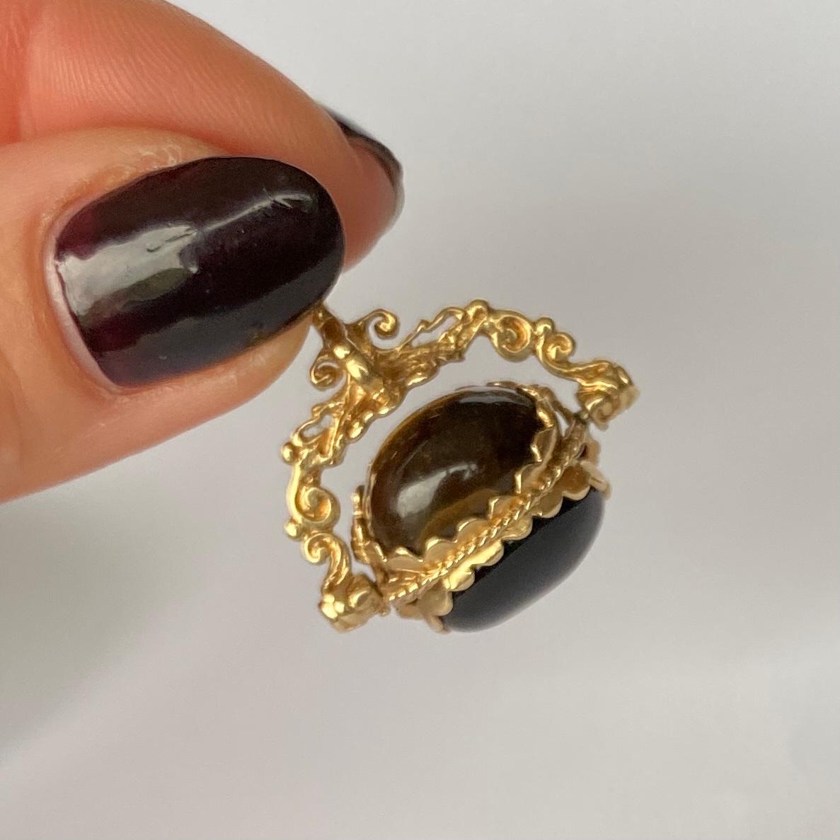 This gorgeous fob pendant contains three oval sides of  carnelian, tigers eye and onyx forming a triple side swivelling fob. Which is pivoted beneath a decorative arch and pendant loop. Modelled in 9ct gold. 

Height inc loop: 30mm

Weight: 7.9g
