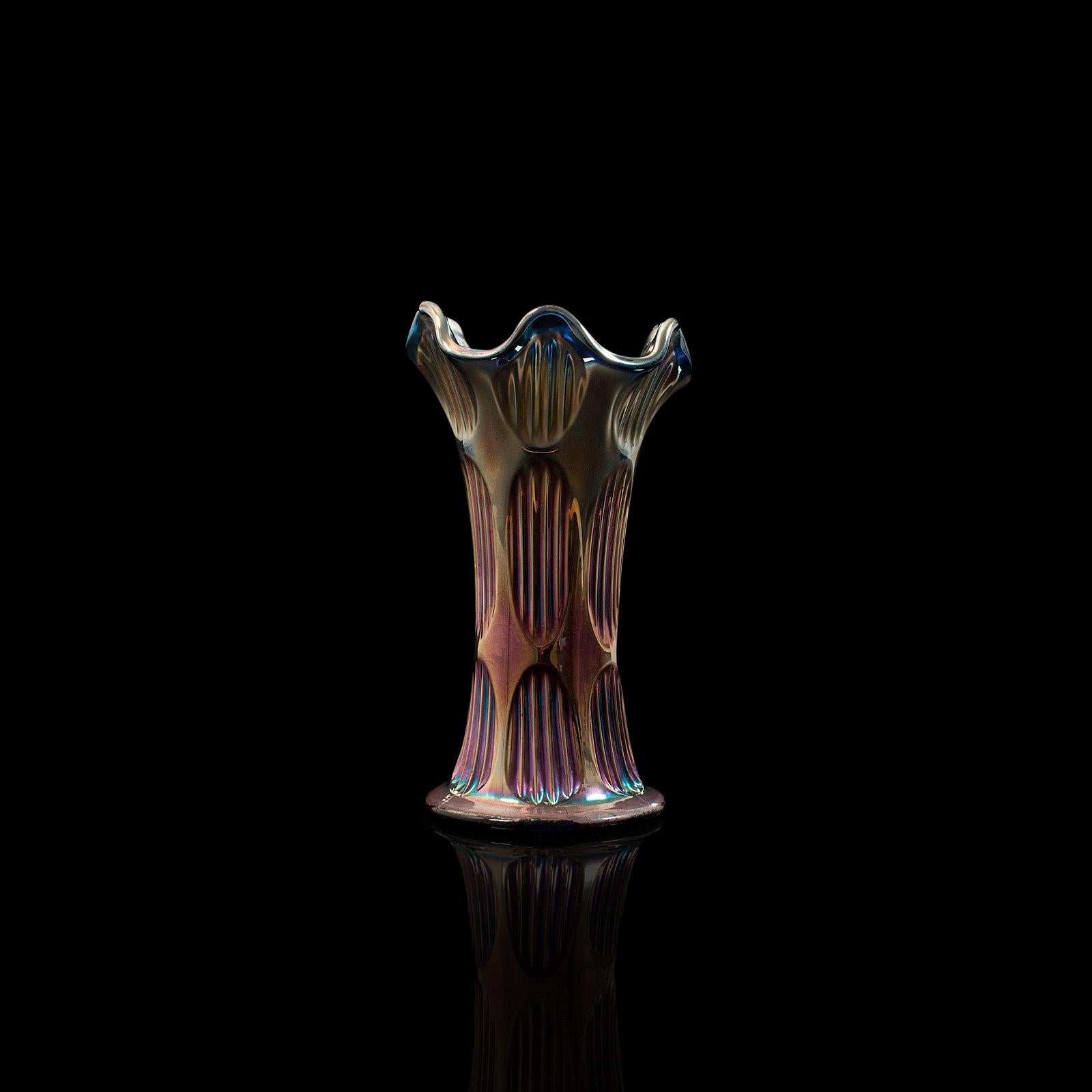 This is a vintage carnival vase. An English, iridescent glass decorative display vase, dating to the mid-20th century, circa 1950.

Eye-catching piece with an array of color
Displaying a desirable aged patina
Iridescent glass with reeded finish