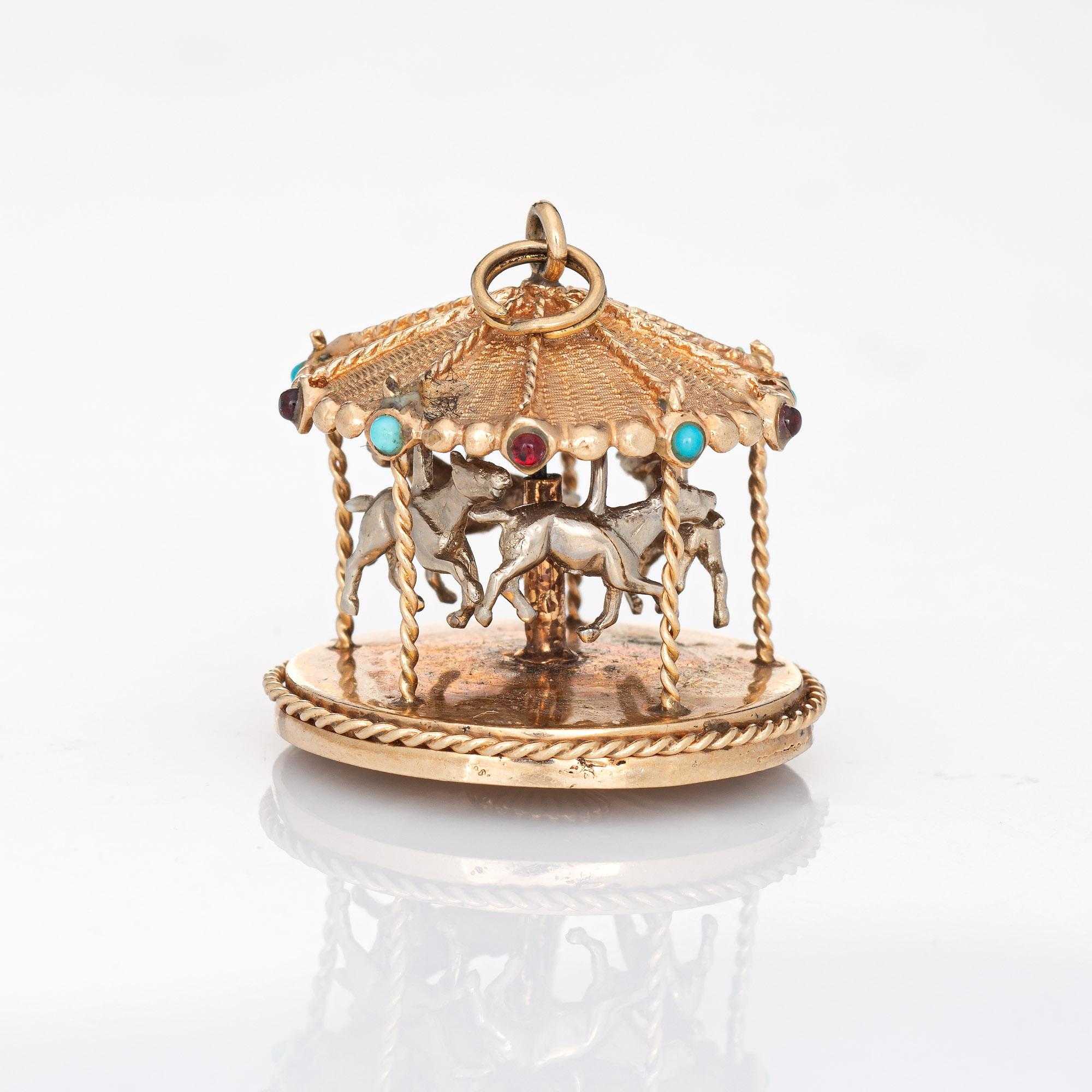 Finely detailed vintage Carousel charm crafted in 14k yellow gold (circa 1960s).  

Turquoise and garnet cabochons are set into the canopy of the charm. Note: one garnet is missing.  

The unique charm is crafted in the form of a merry-go-round. The