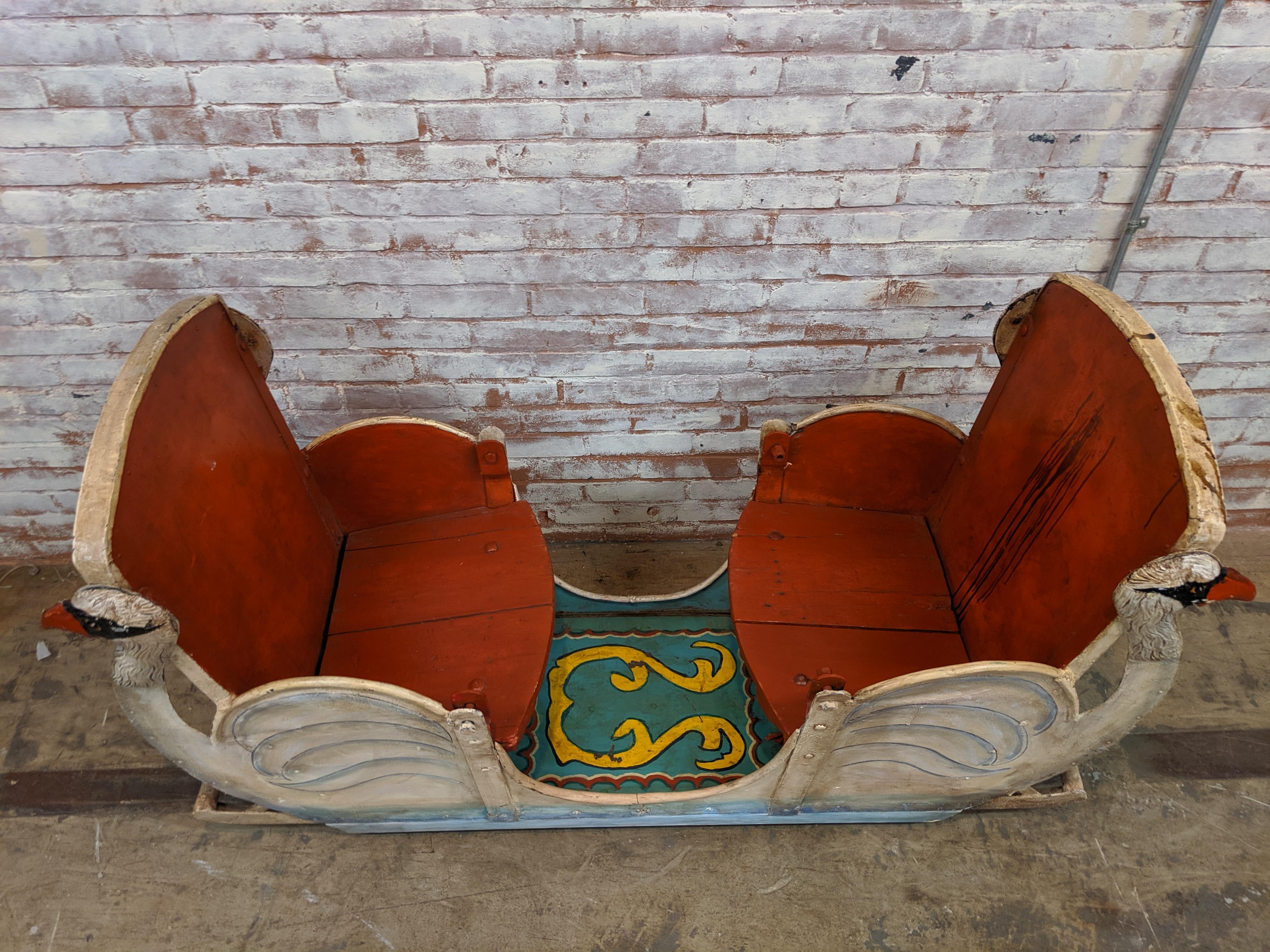 Vintage 20th century carousel seat with swan motif on all four sides. A great piece of Americana and super conversation piece. Constructed of metal and hand painted. The seats are wood but seat backs and sides are metal. Great piece to fill with
