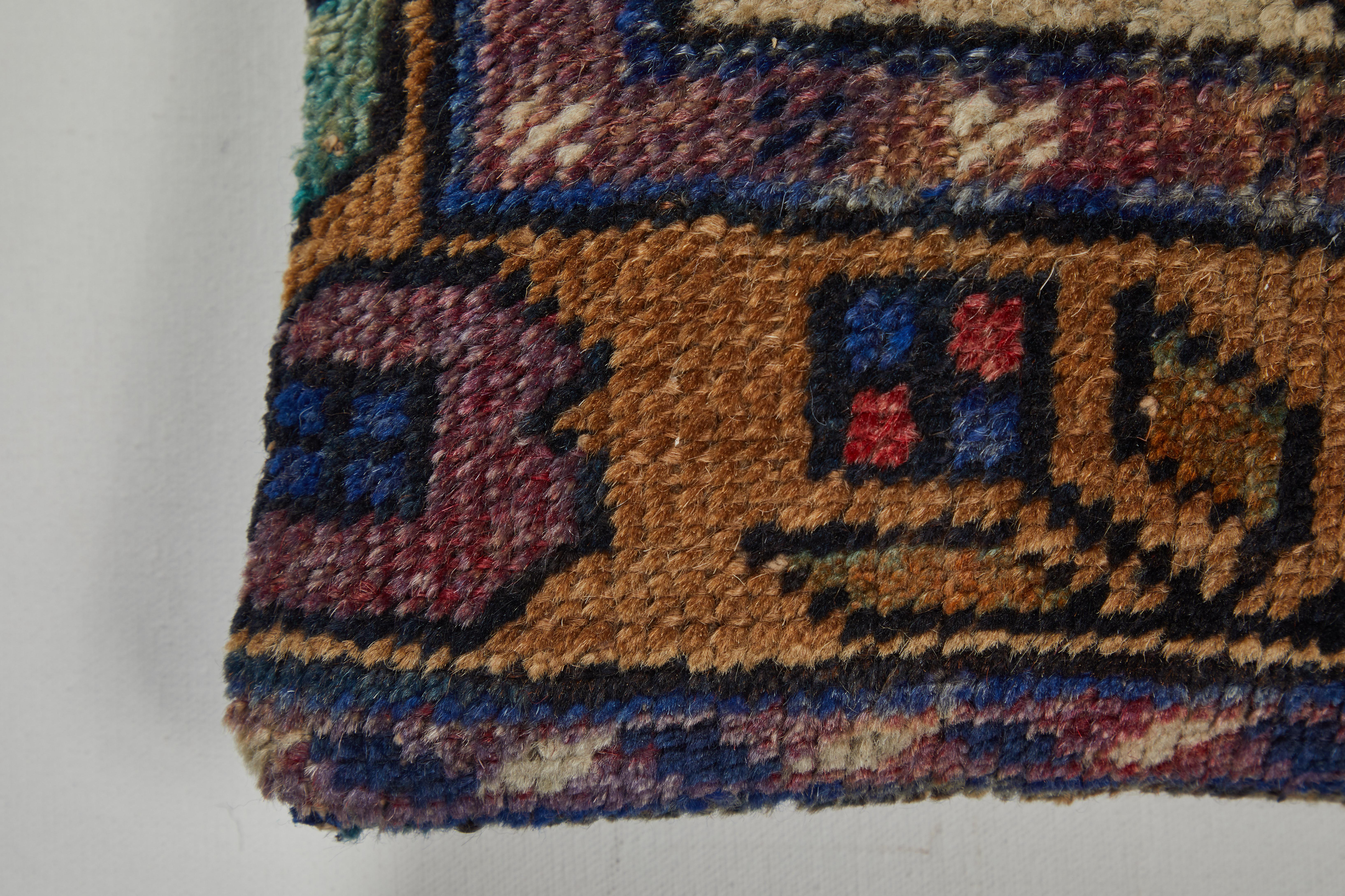 Tribal rug fragment with vase and flowers. Gold, blue, red, green, ivory. Dark grey cotton back. Zipper closure and feather and down fill.