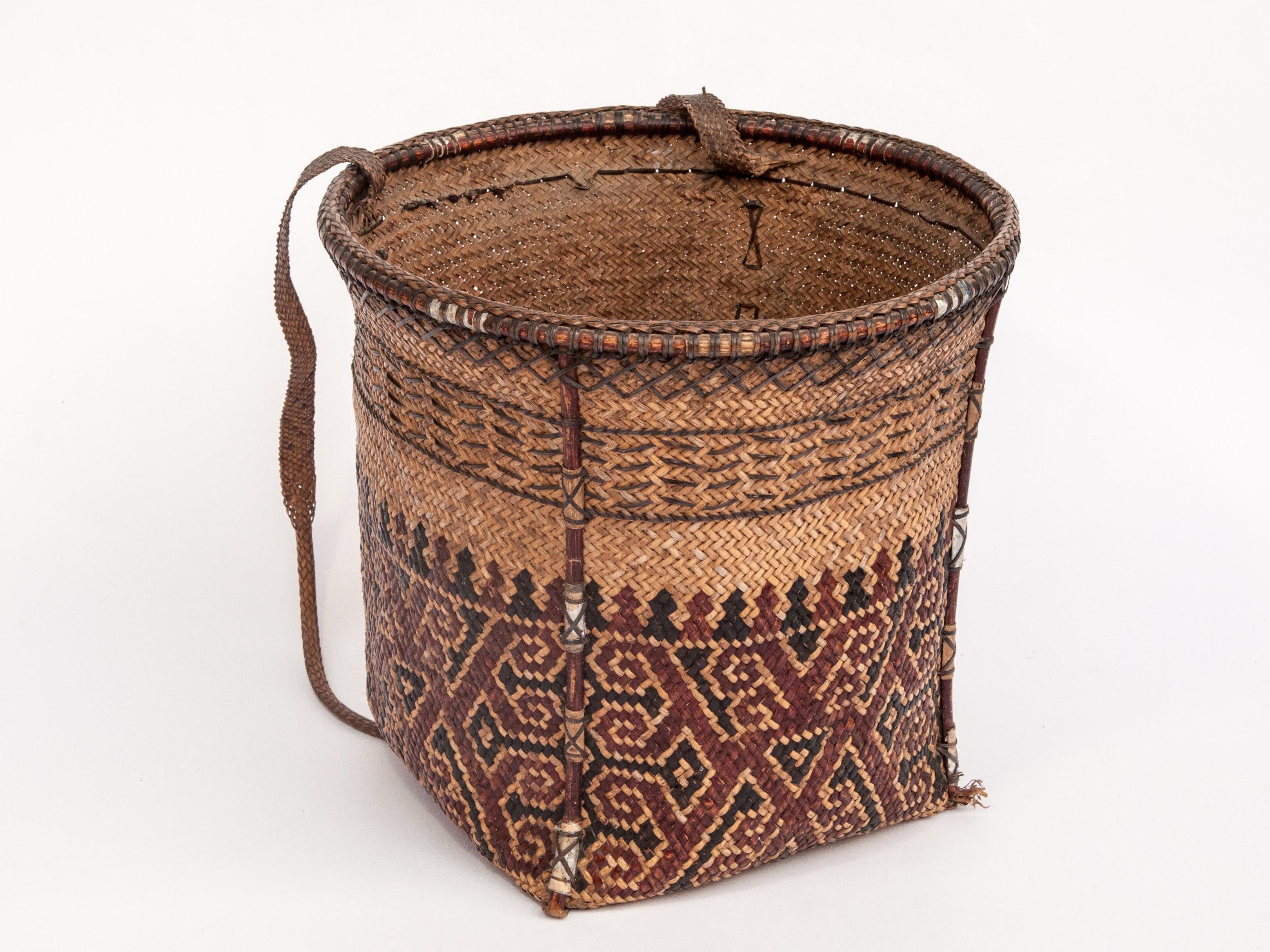 Vintage carrying basket with woven design, Ngaju Dayak of Borneo, mid-20th century.
This small sturdy basket comes from the Ngaju of Central Borneo, and comprises rattan plaiting reinforced with a bamboo rim and splines. The design incorporates