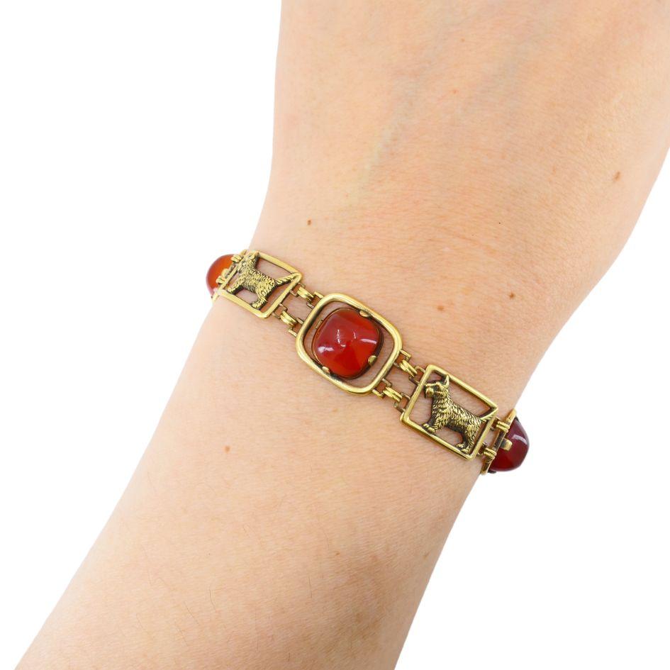 This vintage 14k gold bracelet by Cartier blends charming design with collectible craftsmanship. Featuring four bezel-set cabochon carnelian stones, the bracelet alternates with open-frame links depicting the Scottish terrier, a beloved dog breed