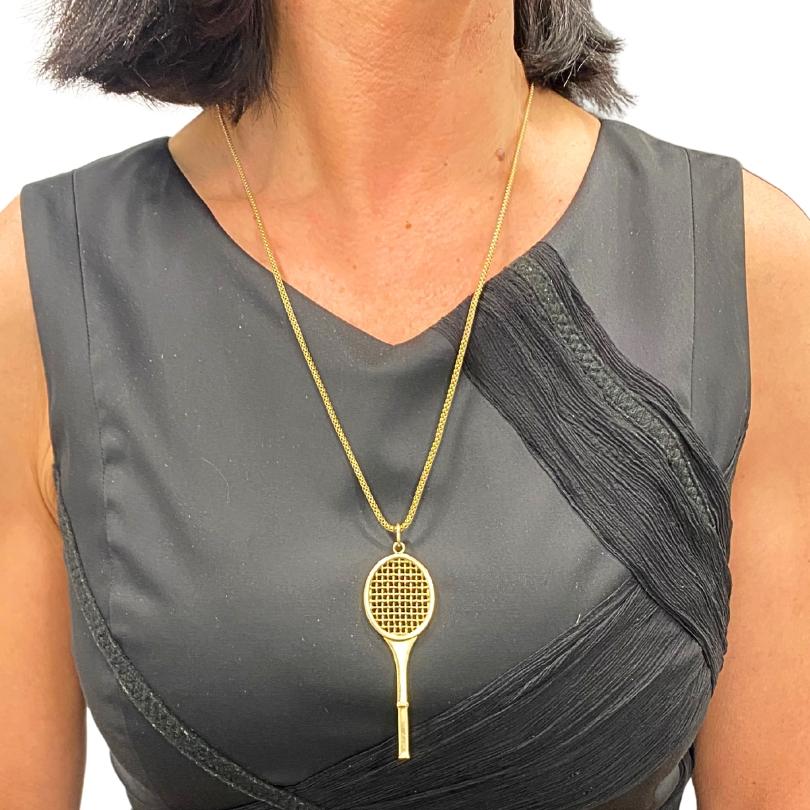 Este elegante collar incluye un colgante de raqueta de tenis de oro de 14 quilates finamente elaborado por Cartier, célebre por sus refinados detalles y lujoso acabado. El colgante raqueta de tenis se elaboró prestando atención al entramado de las