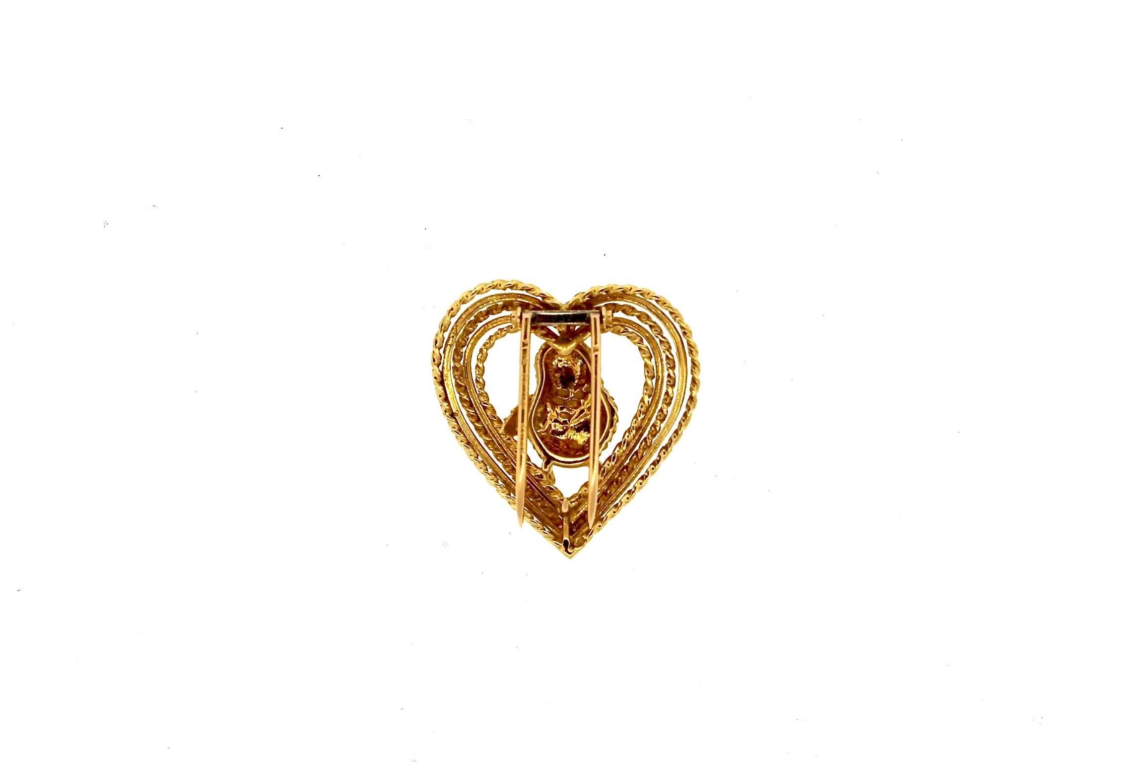 Whimsical and collectible 18k yellow gold lover bird pin in heart by Cartier circa 1960. Cartier is known for making romantic and whimsical jewels throughout the century.  This lovebird perched in a heart is a classic symbol of love. Cartier made a
