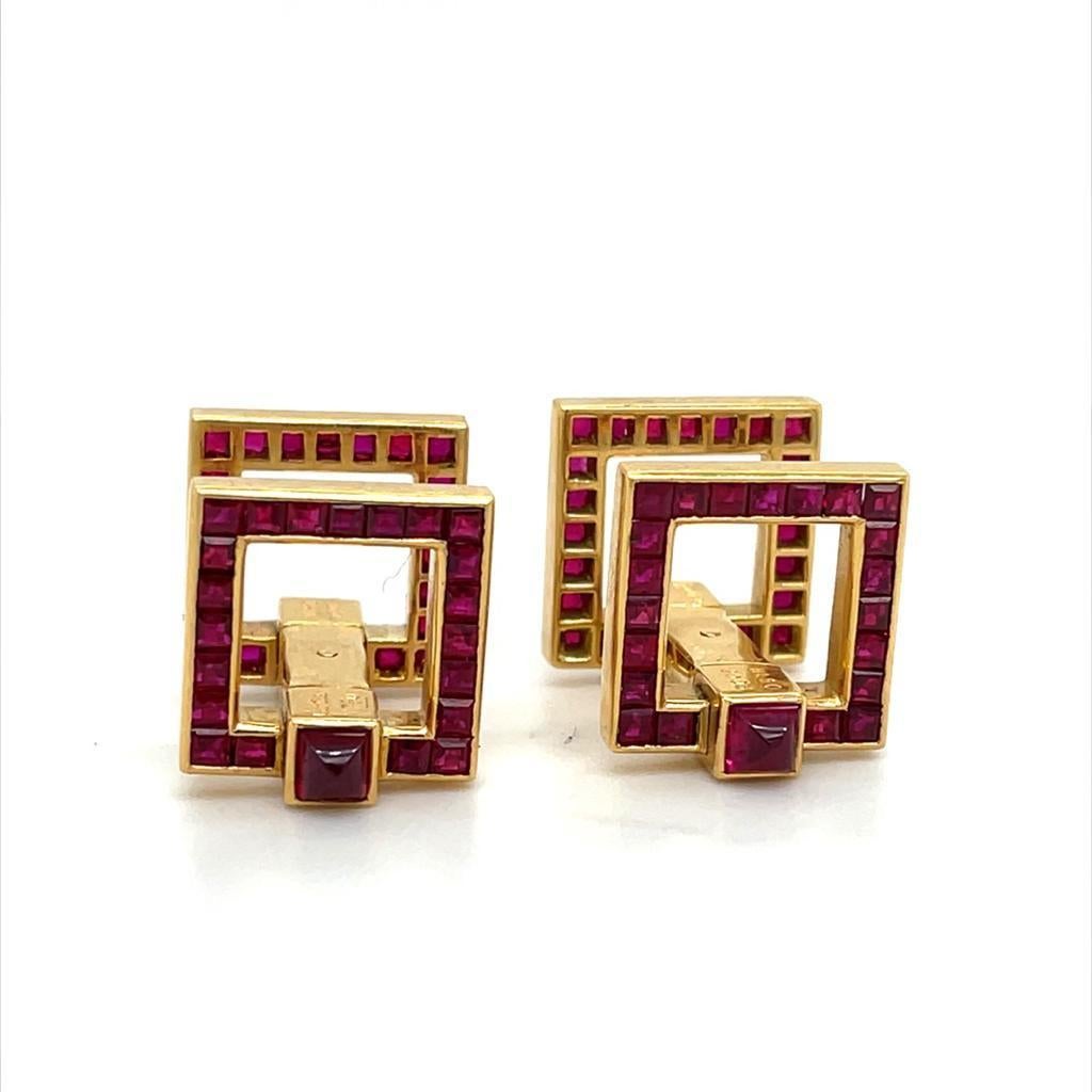 A vintage pair of Cartier 18 karat yellow gold stirrup cufflinks, circa 2003

Channel set with calibré cut deep red rubies to one side and finished with a domed cabochon cut ruby to either end of the hinges. With a total ruby weight of 1.40 carats