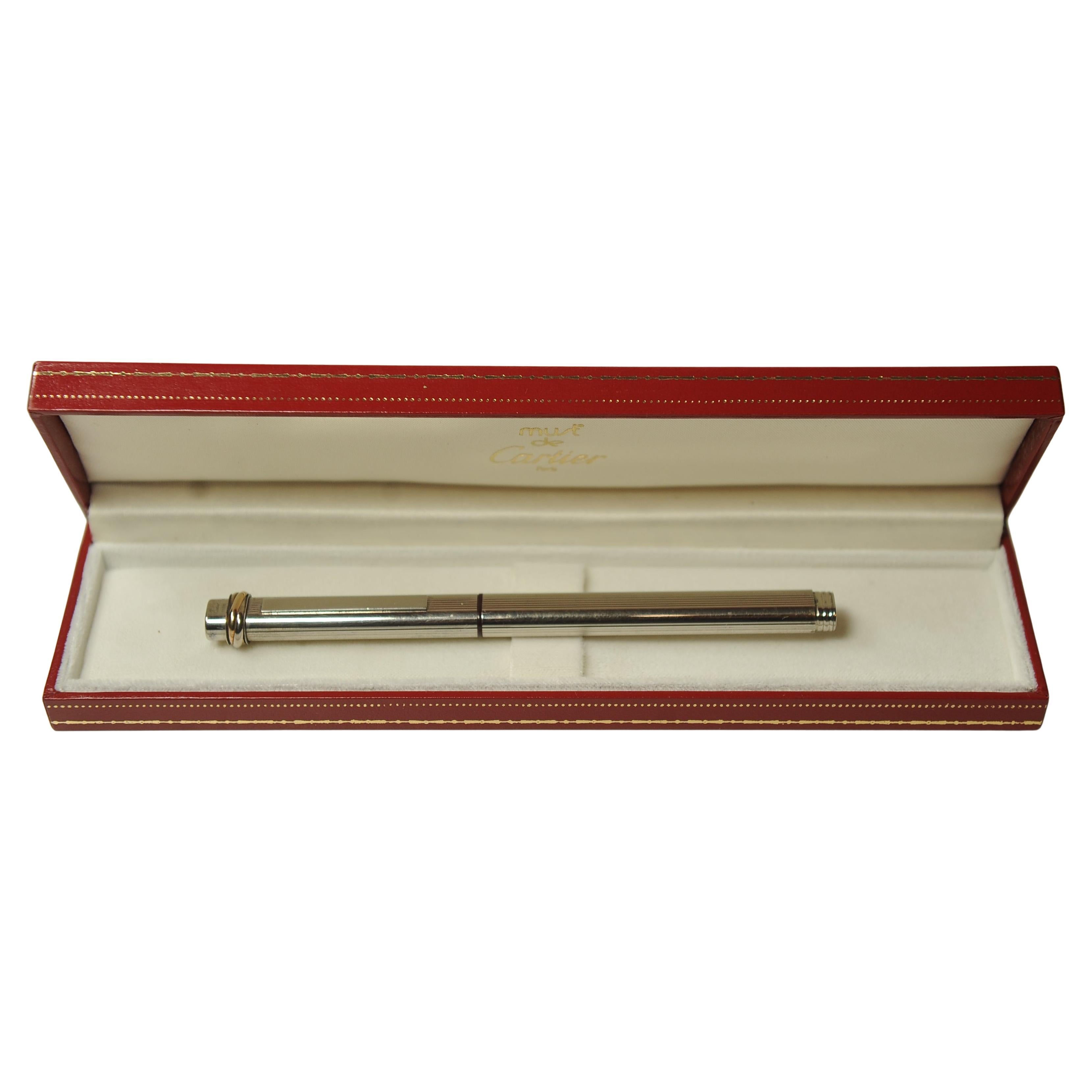 Penna stilografica Trinity d'epoca Cartier con pennino placcato oro 18 ct, scatola di presentazione Cartier e cartucce d'inchiostro 

Questa penna stilografica Must de Cartier ha un corpo in metallo argentato con motivo a gadroon. 

Rifinito con