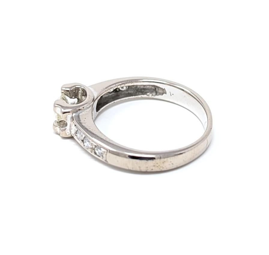 Vintage 18k solid white gold Cartier ring featuring dazzling diamonds, signed on the interior of the band. Best measures for a US size 6 finger, measures .2 inch at its tallest points by .1 inch at its smallest points. The center diamond measures
