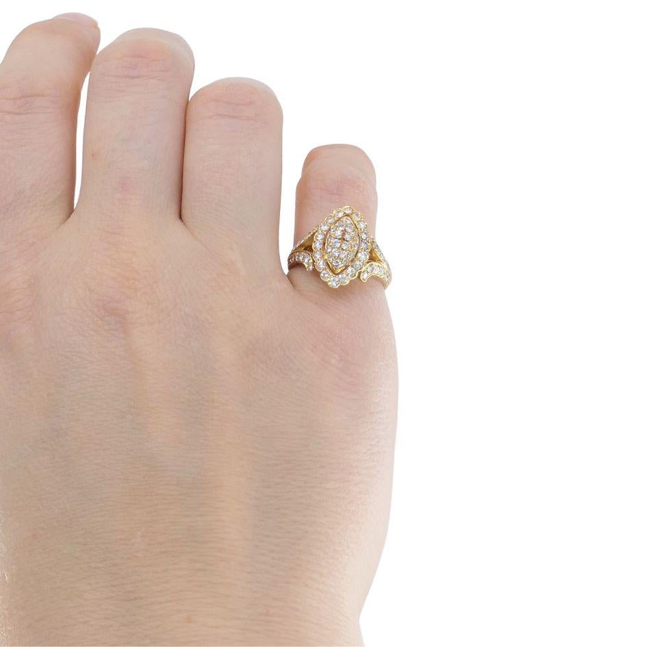 This vintage Cartier marquise cluster ring, crafted in 18k yellow gold, features a bold pave diamond design. The marquise-shaped center is fully set with round brilliant-cut diamonds, with additional diamonds along the shoulders for continuous