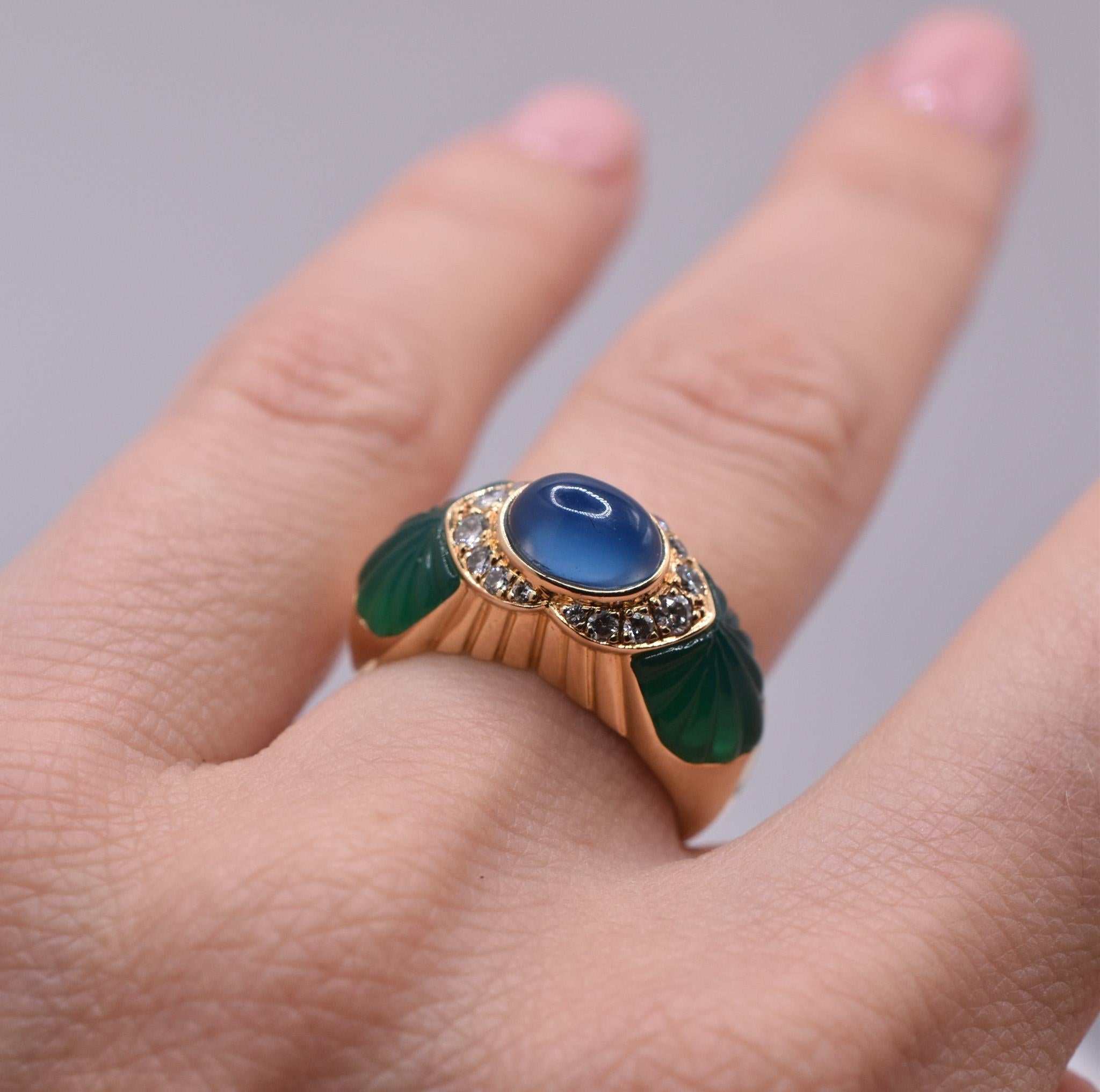 Cartier Sapphire and Chrysoprase ring in 18k Gold, showcasing a wonderful Natural Cabochon-cut Sapphire at the center with Carved Chrysoprase shoulders and further embellished Diamond accents.

Made in France, circa 1980.

We original documents from