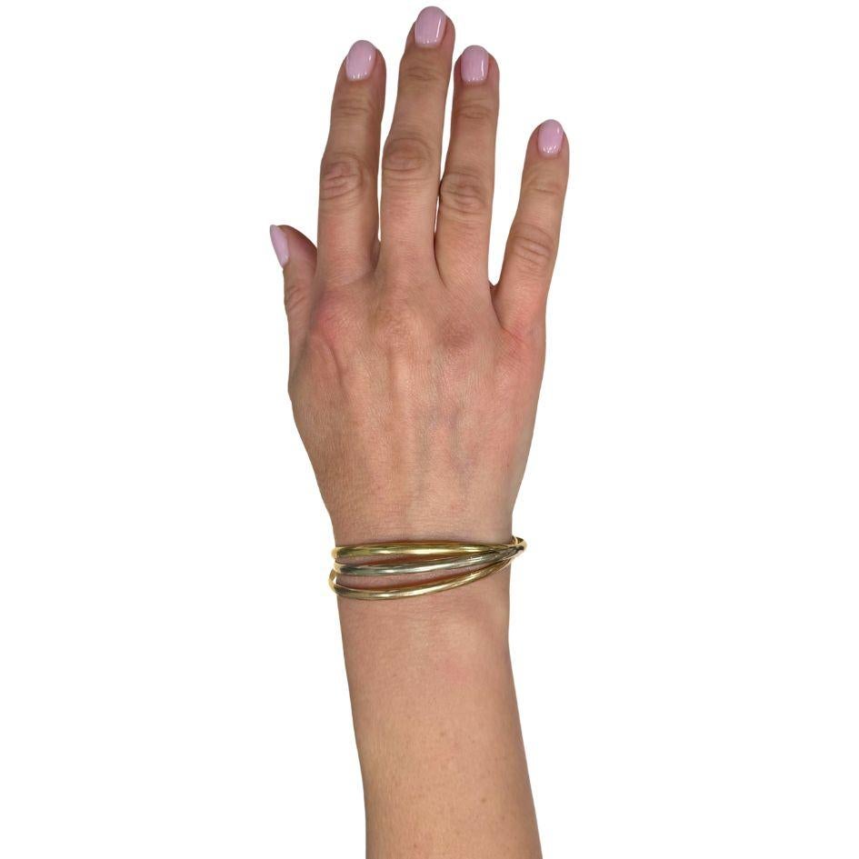 The Vintage Cartier 18k Gold Trinity Bangle Bracelet is an iconic jewelry piece featuring three interlocking bangles in yellow, white, and rose gold. Crica in the 1980s, this Cartier bracelet symbolizes unity and elegance. Crafted from 18k gold,