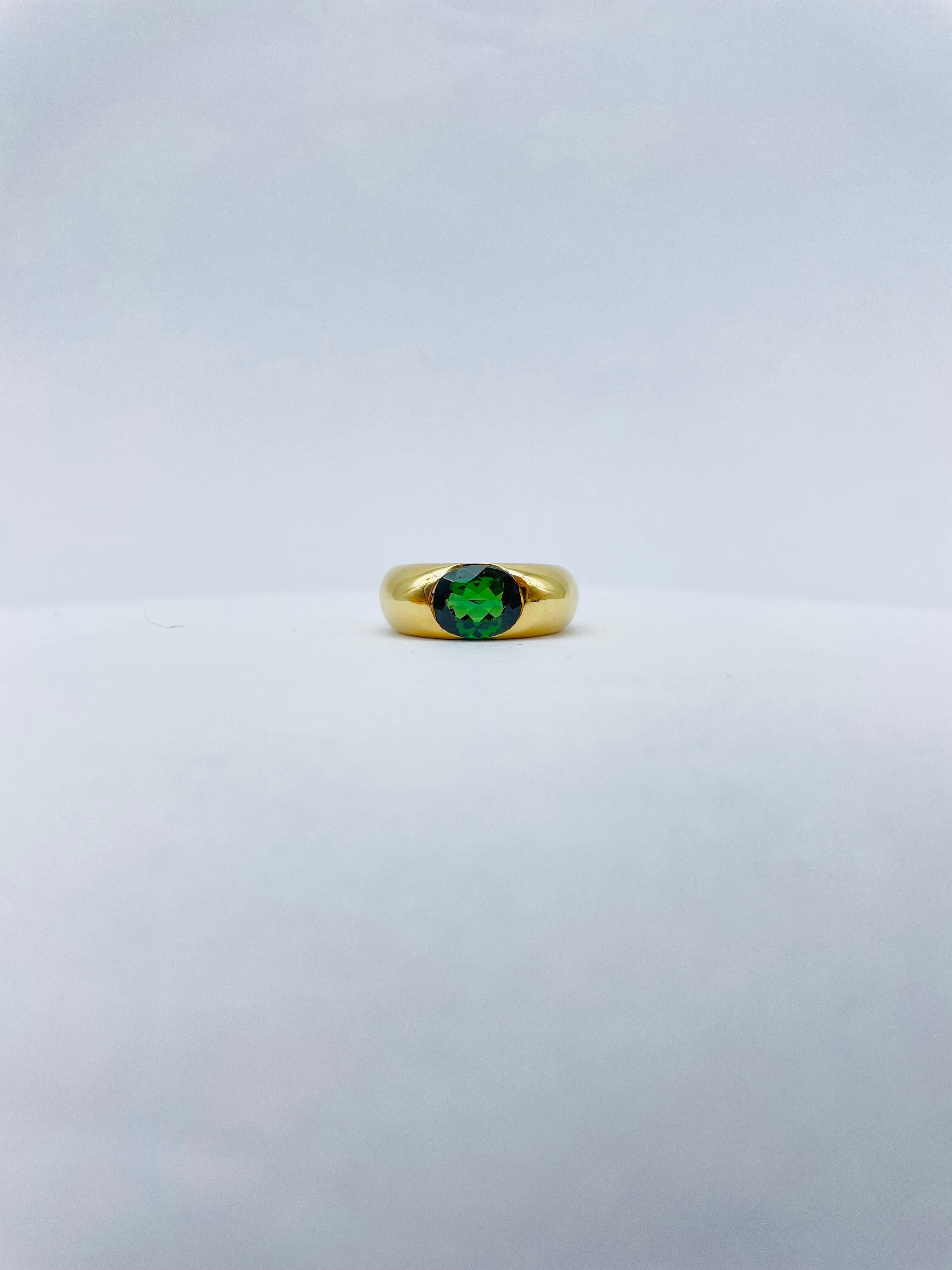 Introducing the magnificent Vintage Cartier 18K Ring, a true masterpiece that exudes luxury and sophistication. Crafted from the finest 18k yellow gold, this Big Ellipse Tourmaline Band Ring by Cartier is a rare and coveted treasure that dates back