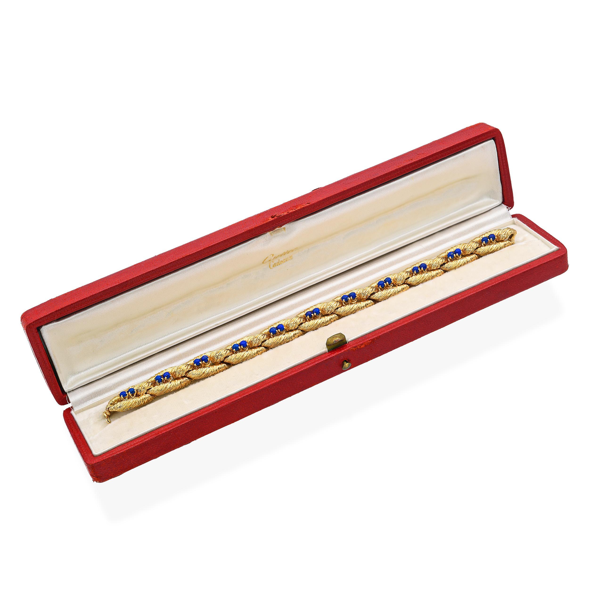 This rare and collectible vintage Cartier bracelet is exquisitely crafted in luxurious 18k yellow gold and features a striking woven link design attributed to the renowned Italian goldsmith Carlo Weingrill. At the center, a richly colored lapis