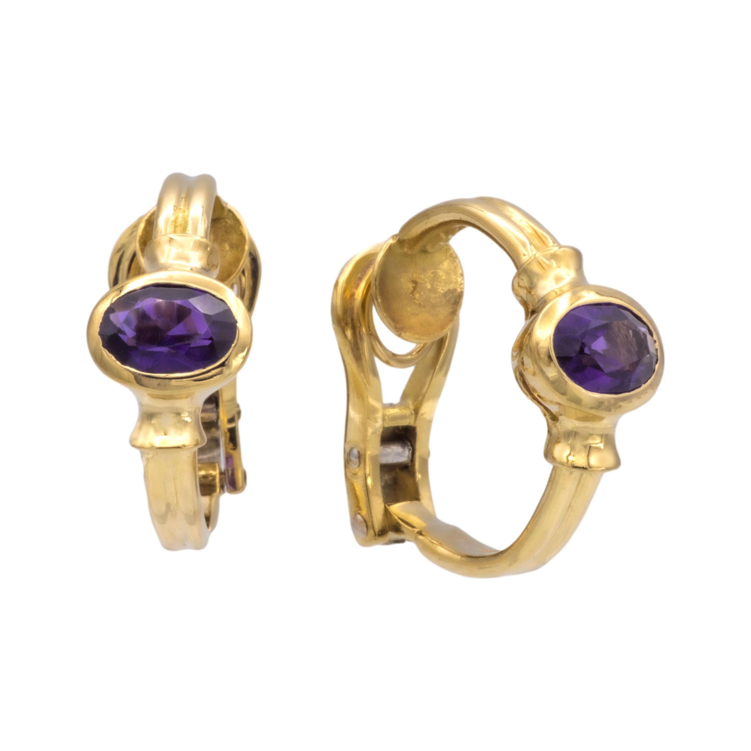 Pair of vintage Cartier huggie earrings finely crafted in 18 karat yellow gold featuring 2 oval center amethysts set horizontal inside bezel settings weighing 0.65 carats approximately each. Earrings measure 0.75