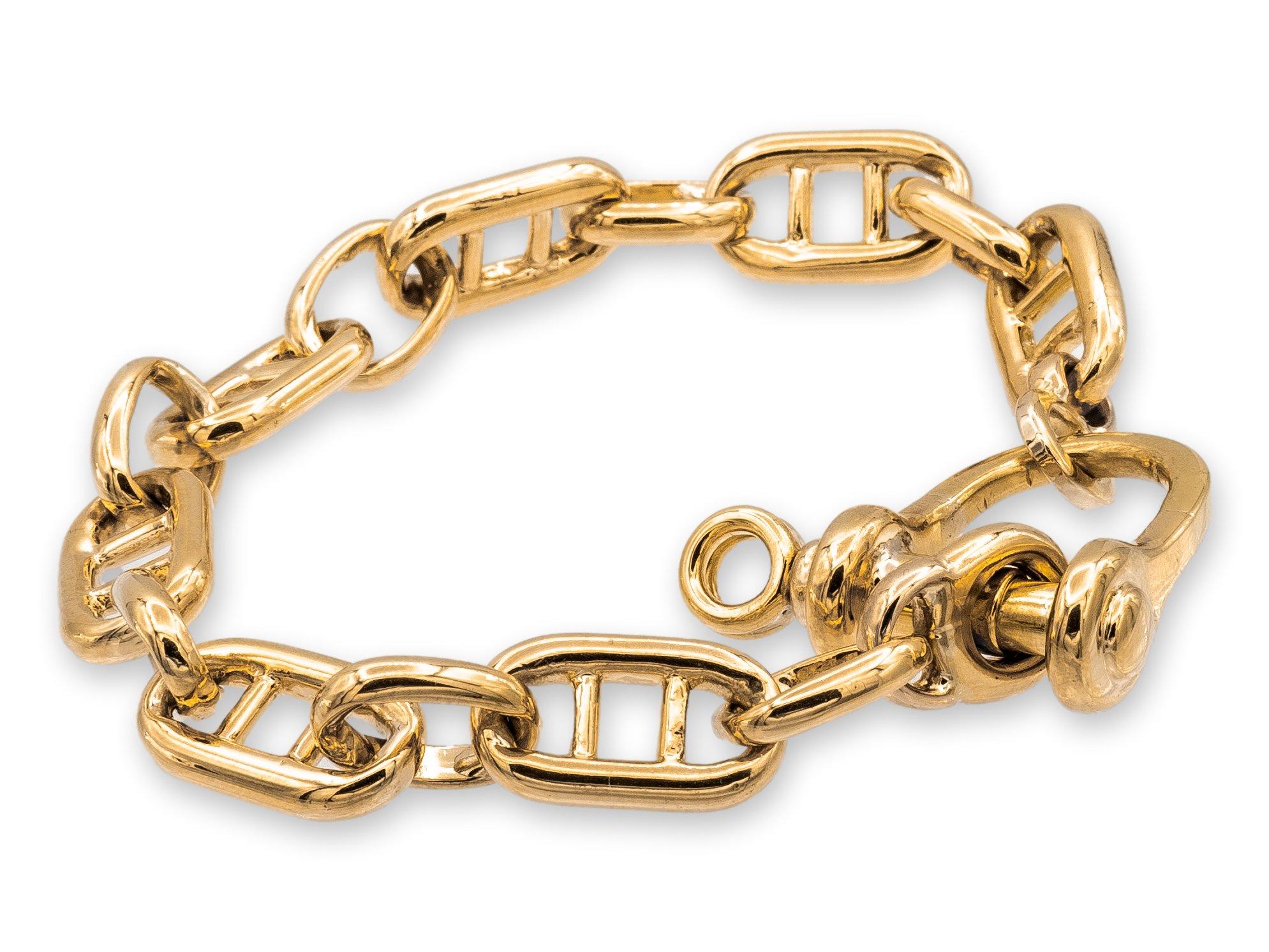 This vintage 1970's Cartier bracelet is made of 18 karat yellow gold and features wide, double bar nautical links that interlock with oval links. It measures 9 inches in length and 11.4mm by 10.2mm in width, and has a large 