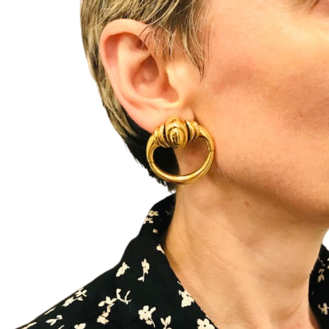 Diese Vintage-Ohrringe aus 18-karätigem Gold wurden in den 1970er Jahren von Aldo Cipullo für Cartier entworfen und zeichnen sich durch seinen kühnen und skulpturalen Schmuckstil aus. Sie sind wie Türklopfer geformt, haben eine glatte ovale