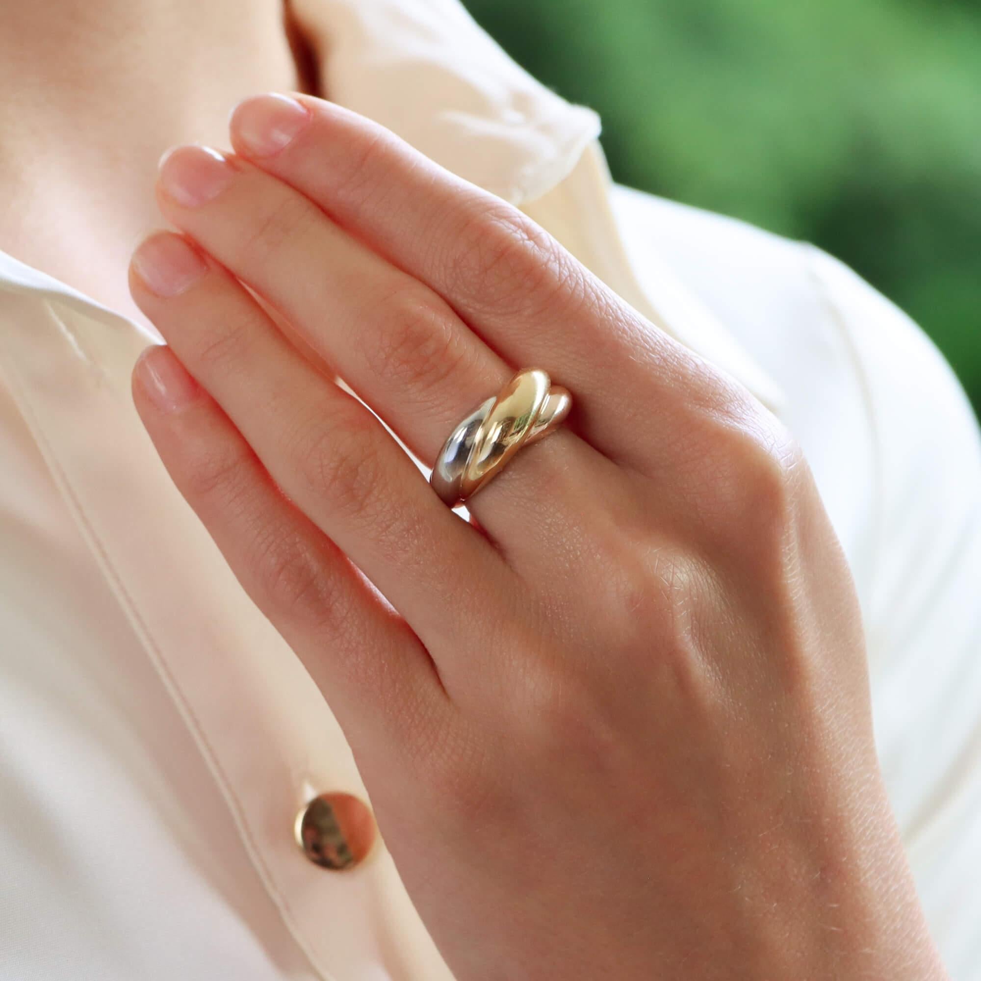 A beautiful vintage Cartier trinity ring set in 18k yellow, white and rose gold.

From a discontinued Trinity collection, the ring is composed of three slightly domed bands. The bands have been soldered together in a striking bombe design which