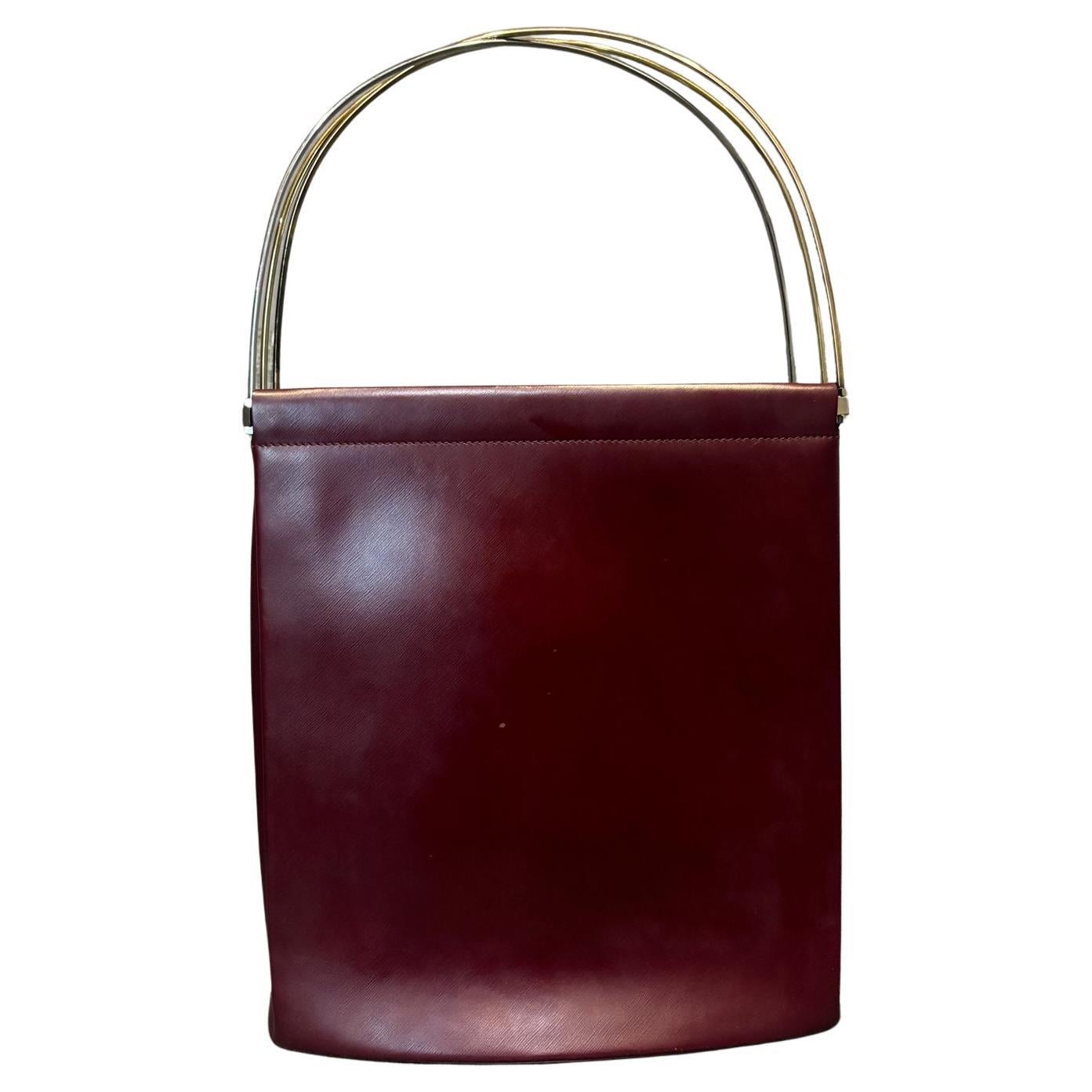 Vintage Cartier Burgundy Trinity tote. Unique design with trinity (gold, rose gold and silver) metal handle. Large enough for everyday bag. Comes with its dust bag. Minor scuffing and scratches throughout. Accordion like opening.
