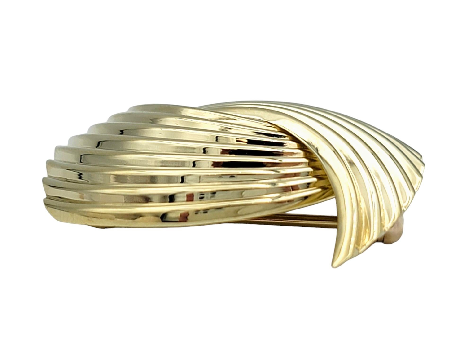 Cette broche vintage de Cartier présente un design unique en forme de pont, réalisé en or jaune 14 carats. La texture striée ajoute de la profondeur et de la dimension à la pièce, lui conférant un attrait sophistiqué et intemporel.

Cette broche