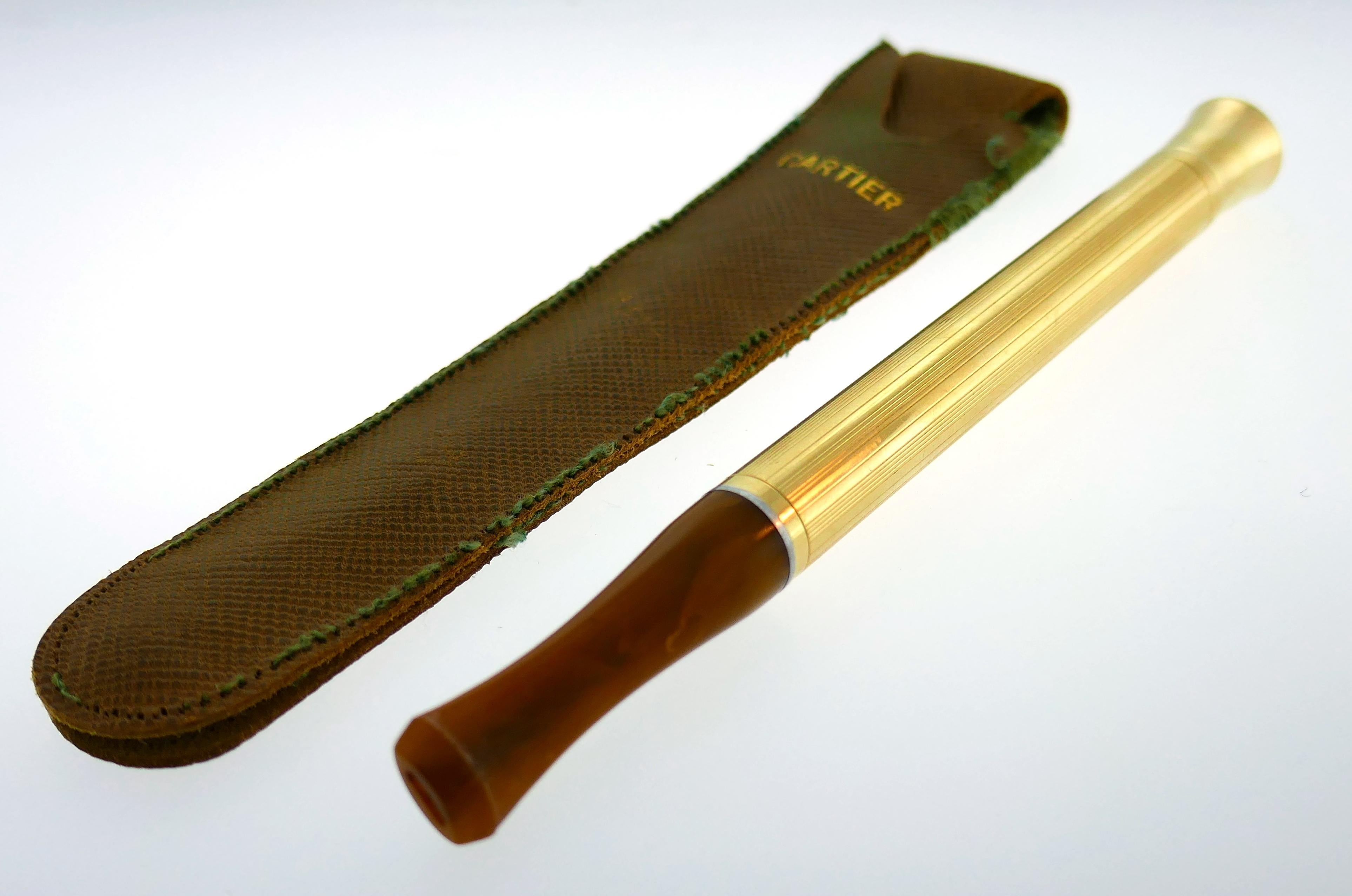 Chic cigarette holder created by Cartier in the 1940s.
it is made of 14 karat (stamped) yellow gold and Bakelite. 
The cigarette holder measures 5 x 3/8 inches, the Bakelite part measures 1-1/2 x 3/8 inches. Weight 14.9 grams.
The cigarette holder