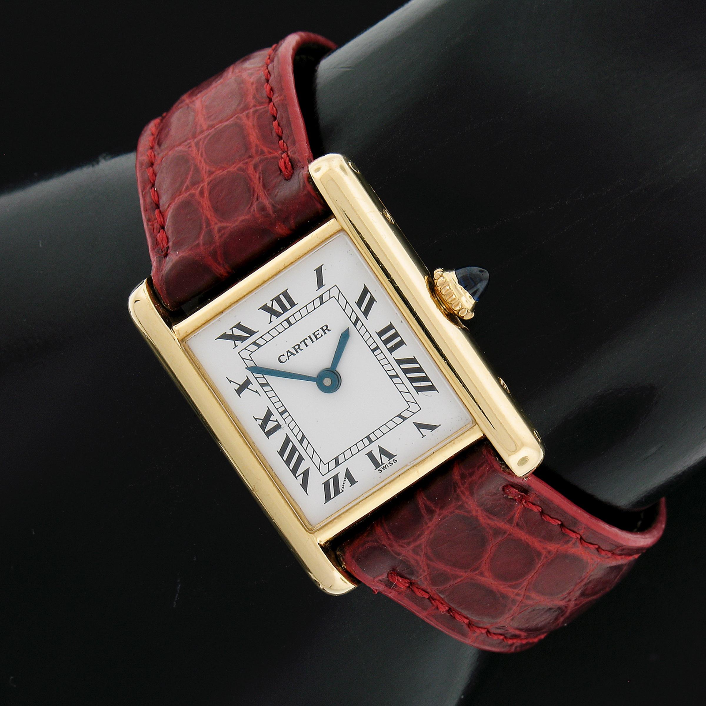 This beautiful classic vintage Cartier Tank watch features a mechanical hand wound Swiss movement mounted in a solid 18k yellow gold case. The watch comes with the original, genuine leather strap from Cartier as well as the original solid 18k gold