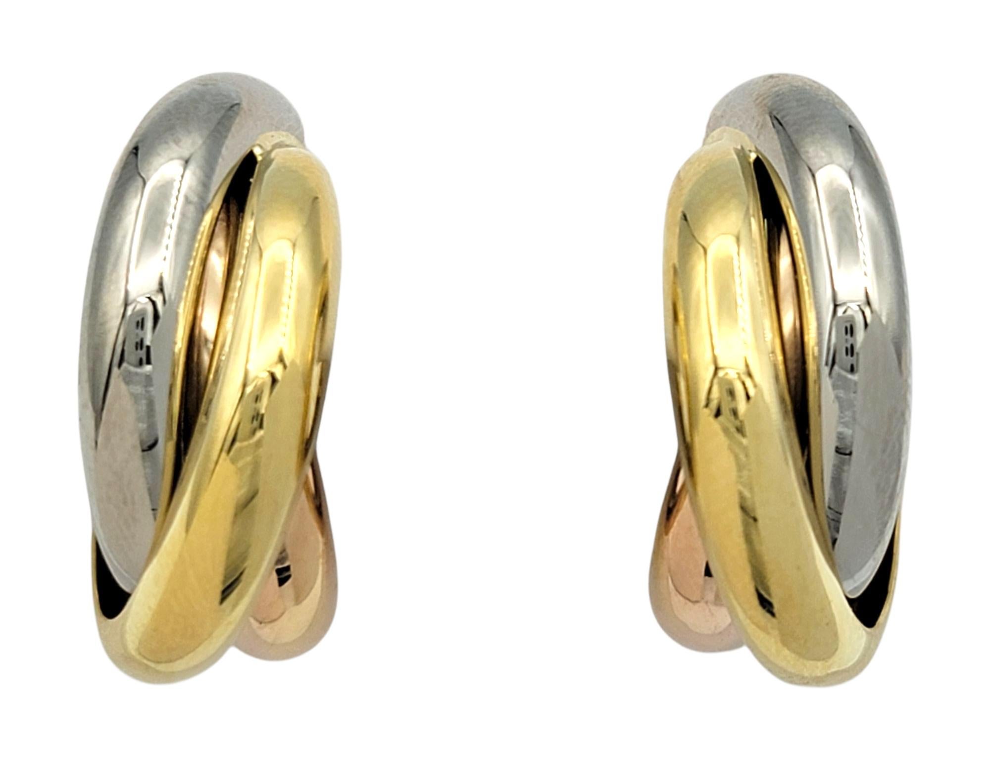 Ces anneaux Trinity vintage de Cartier sont composés de bandes bombées imbriquées en or jaune, blanc et rose 18 carats, formant un design de boucle fluide et intemporel. Chaque bracelet s'enroule doucement autour de l'autre dans un style triple