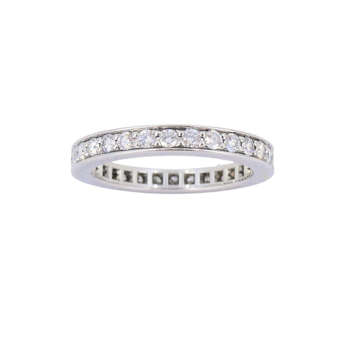 This vintage Cartier band ring is made in platinum and features a full circle of round brilliant-cut diamonds in a channel setting. The band has a flat profile with slightly softened edges. The interior is cleanly finished, and the Cartier signature