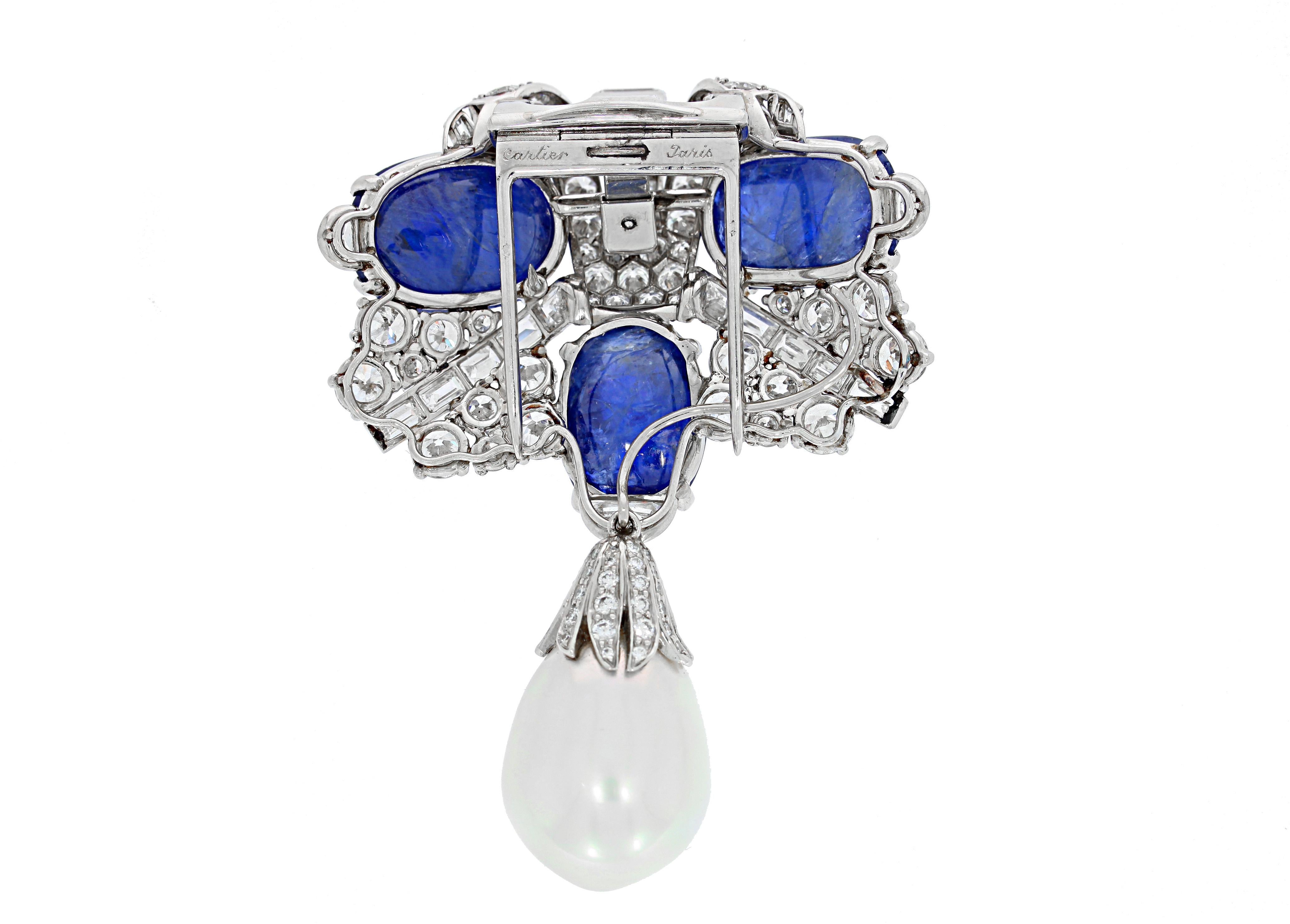 From the iconic house of Cartier Paris, this vintage 1950's platinum brooch consists of 3 cabochon non-heated Burmese sapphires, white diamonds, and a dangling pearl. Signed Cartier Paris. A rare find that will make the perfect addition to your