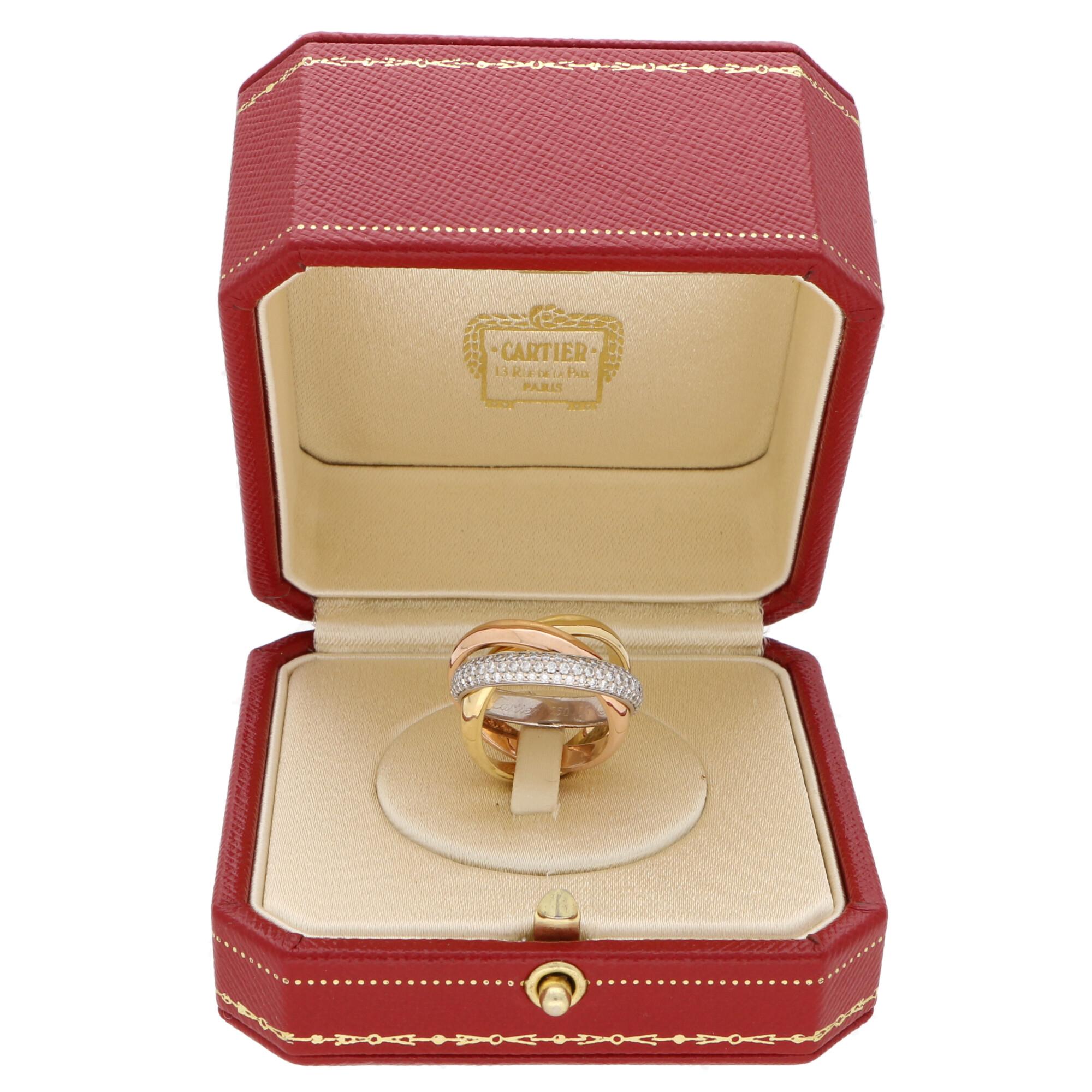 A classic Cartier diamond trinity ring set in 18k yellow, rose and white gold.

The ring is composed of three interlinked 4-millimetre bands that are designed to roll with ease on the finger. The colour difference is subtle yet beautiful and the