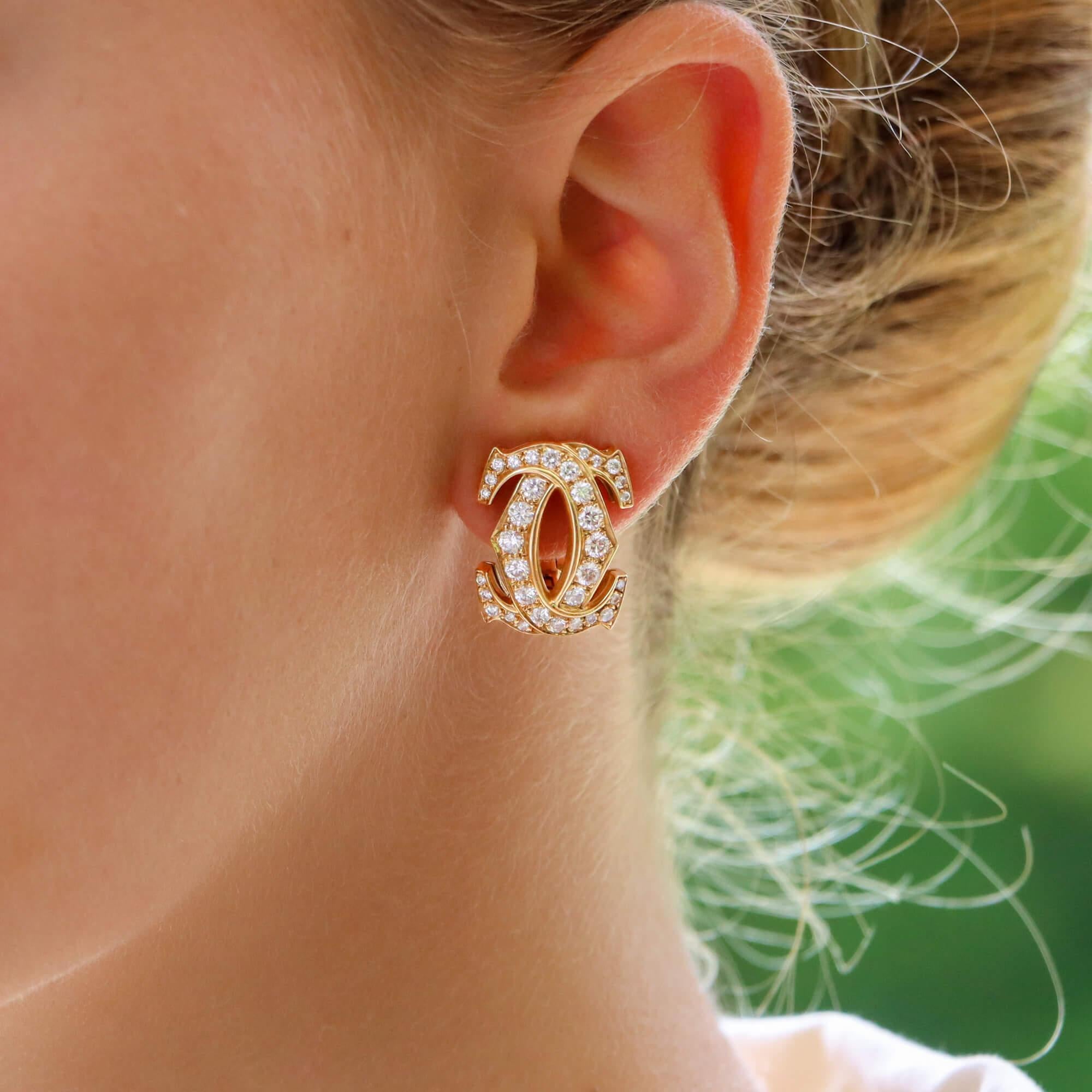 A beautiful pair of vintage of Cartier double C diamond earrings set in 18k yellow gold. 

The pair are each designed in the iconic Cartier double C motif and pave set throughout with 34 round brilliant cut diamonds each. The earrings are secured to