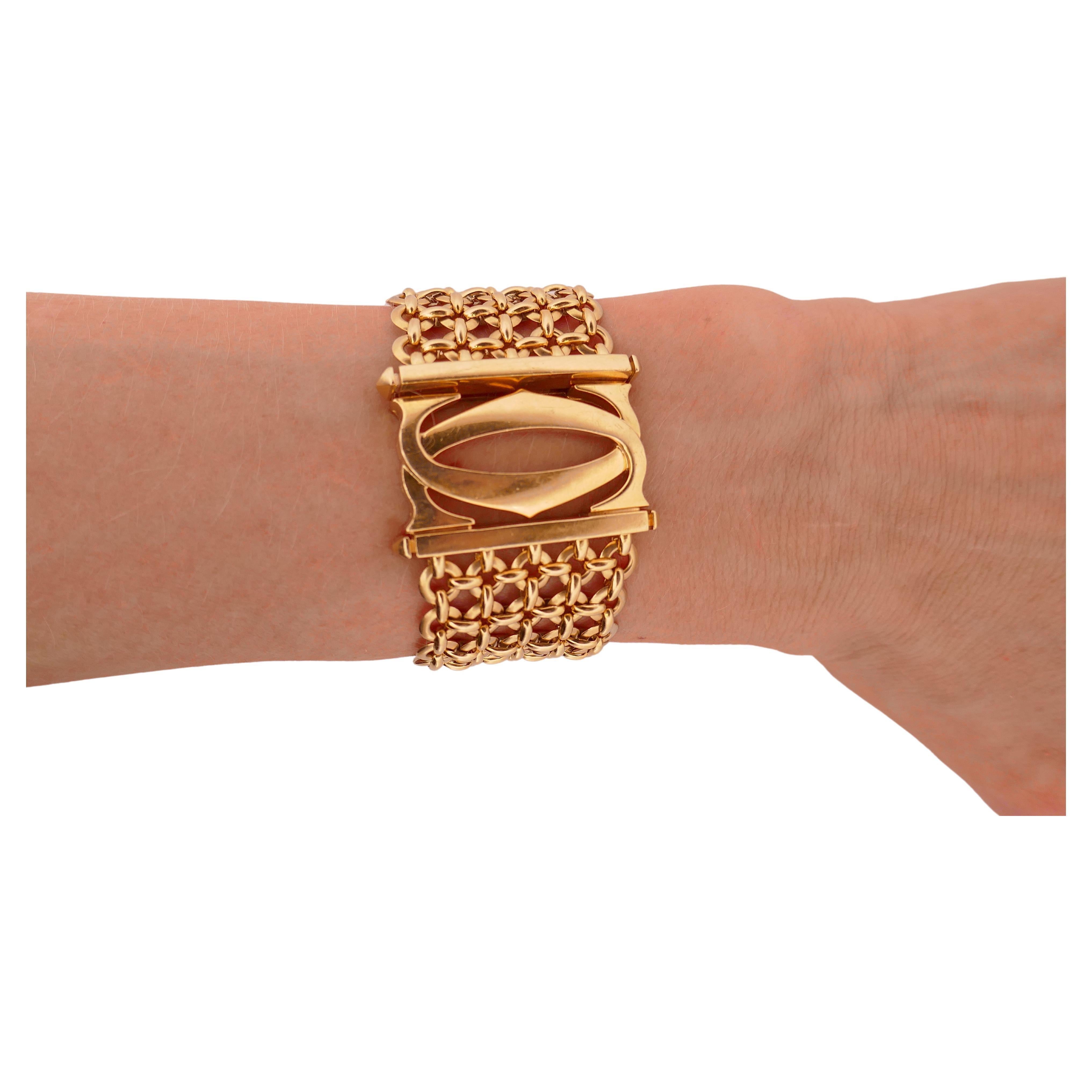 A vintage Cartier Double C 18k gold bracelet from Penelope collection. 
It's a mesh five-row link bracelet with a closure designed as the interlocking double C motif (the Cartier logo). The closure is a hidden push down clasp. 
The mesh comprises of