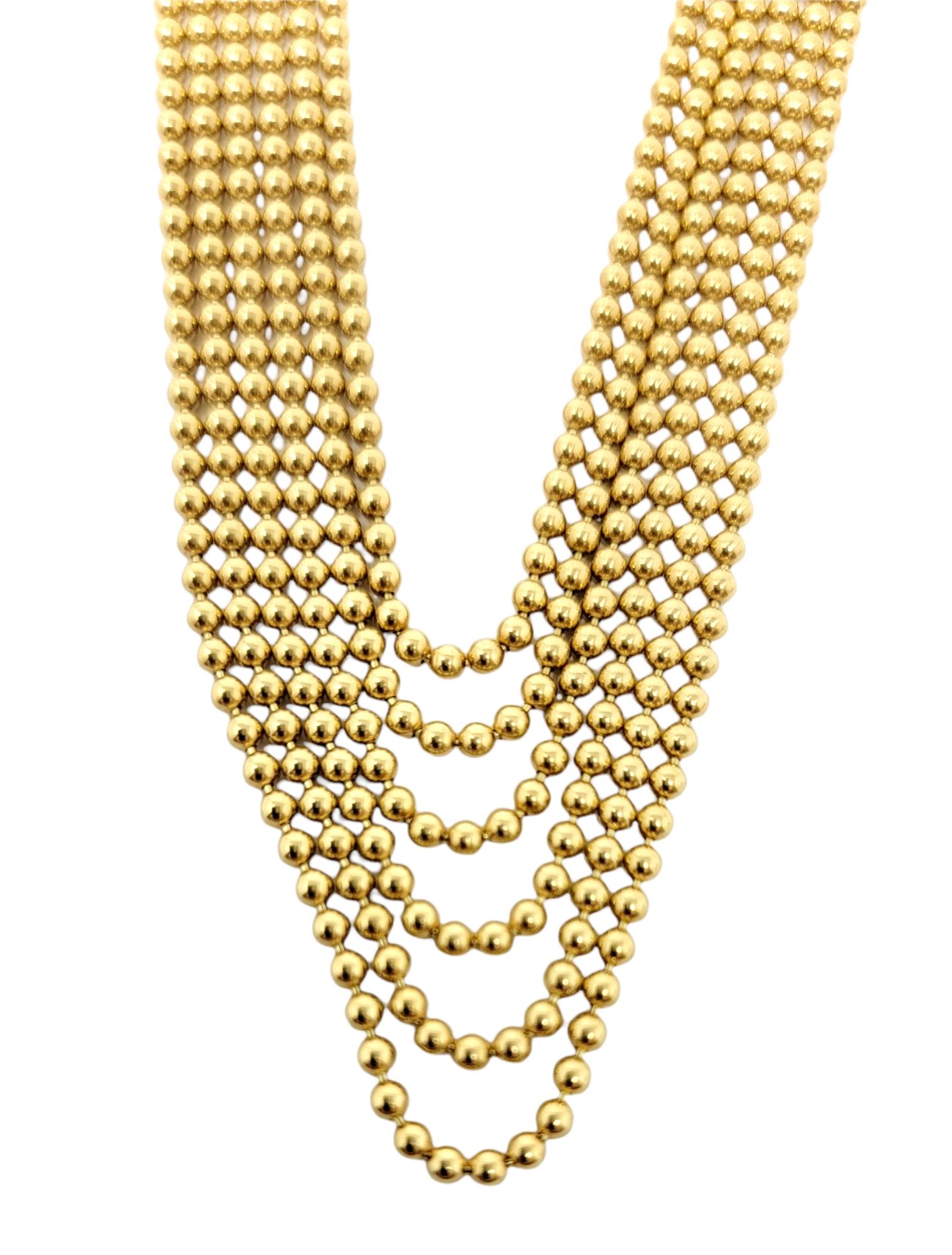 Delicate in style yet bold in design, this amazing six strand necklace from the Draperie Decollete Collection by Cartier is simply stunning. The beautifully made solid gold necklace features 6 individual strands of polished 18 karat gold ball chains