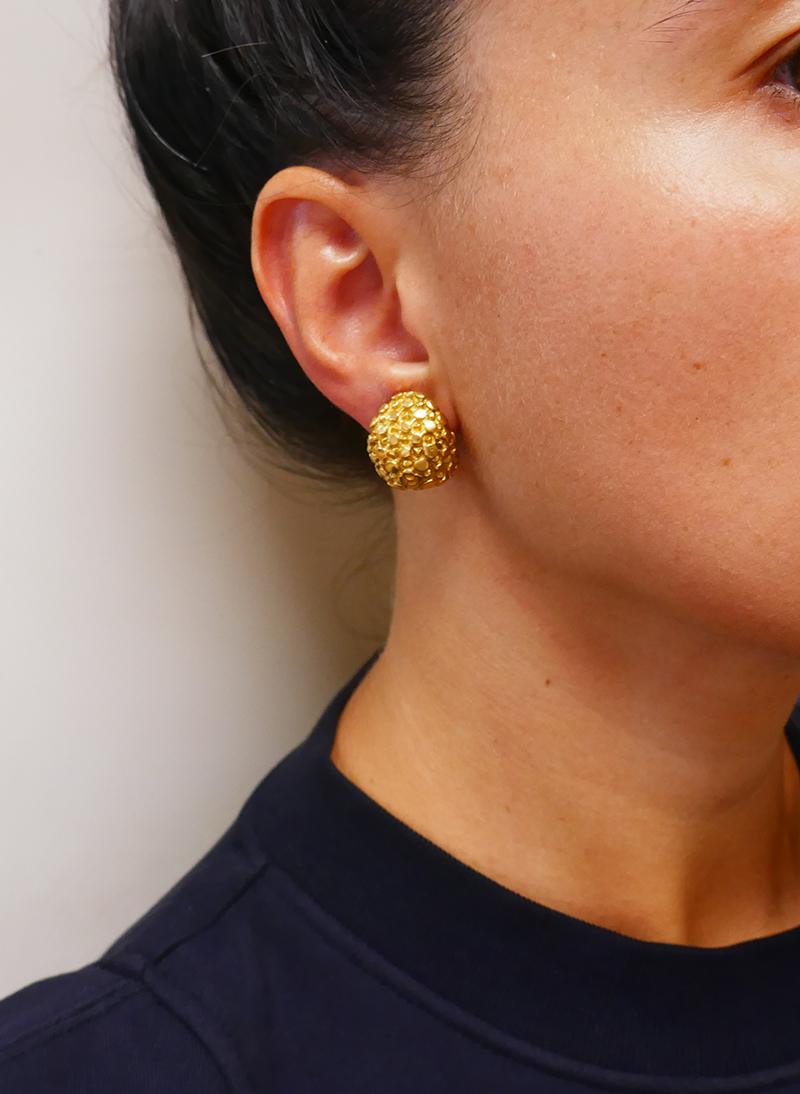 A pair of rare vintage Cartier 18k gold earrings with clip-on closure.
The earrings have an amazing intricate texture. Two layers of the gold “pins” and “buttons” are sitting on different levels. There is a flower-like looking pattern in the middle.