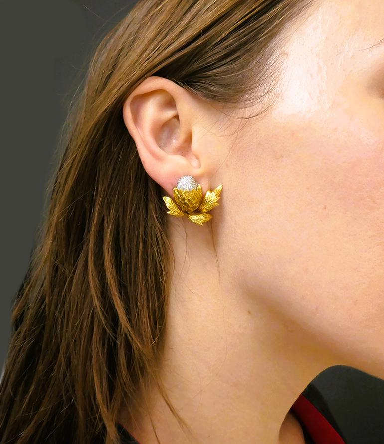 A pair of vintage Cartier earrings of botanical design, made of 18 karat yellow and white gold, accented with diamonds.
With the yellow gold leaves and scale on the bottom and the white gold top the earrings resemble a hop head or an artichoke. The